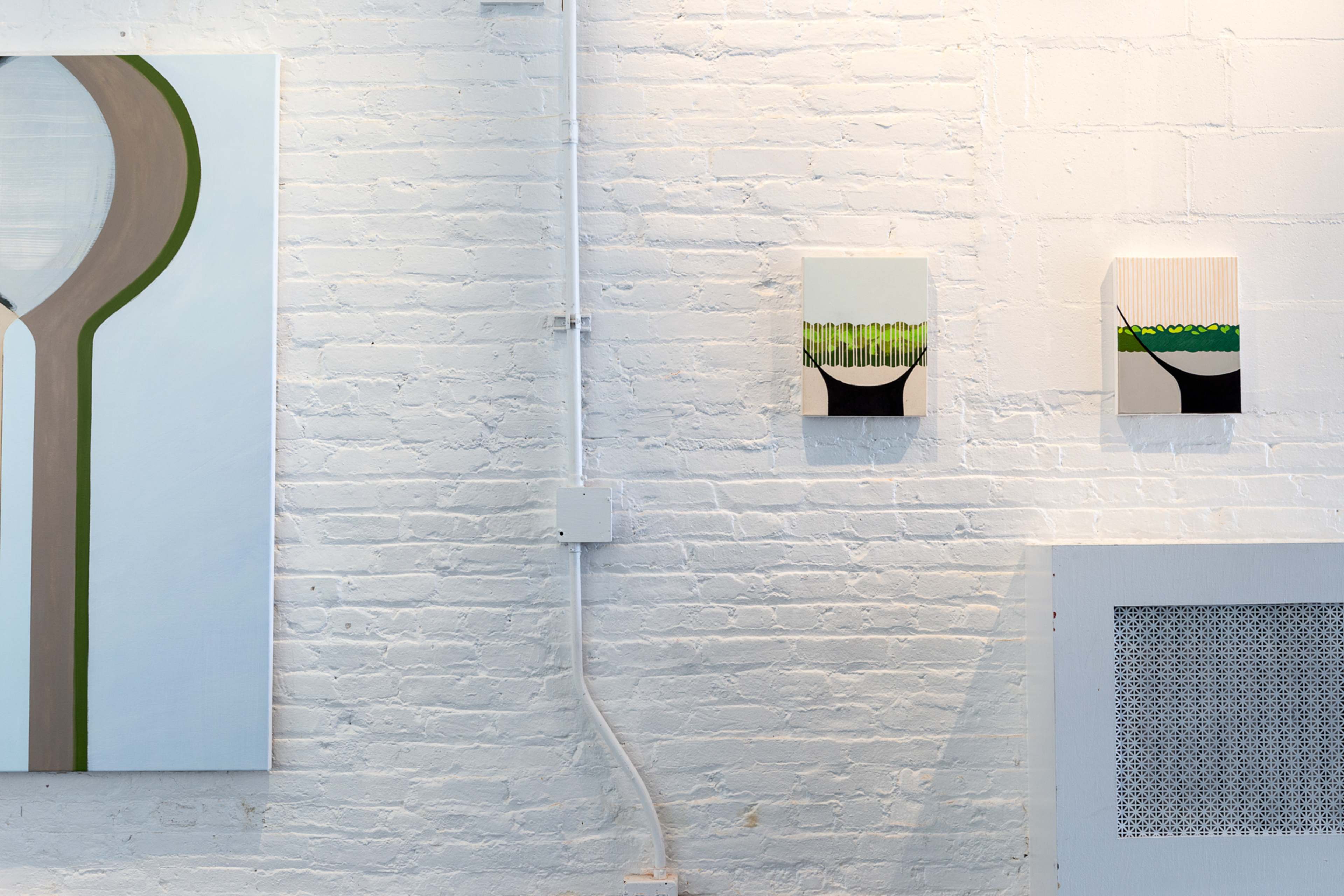 A white brick wall displaying three abstract paintings, two smaller pieces on the right and a larger one on the left.