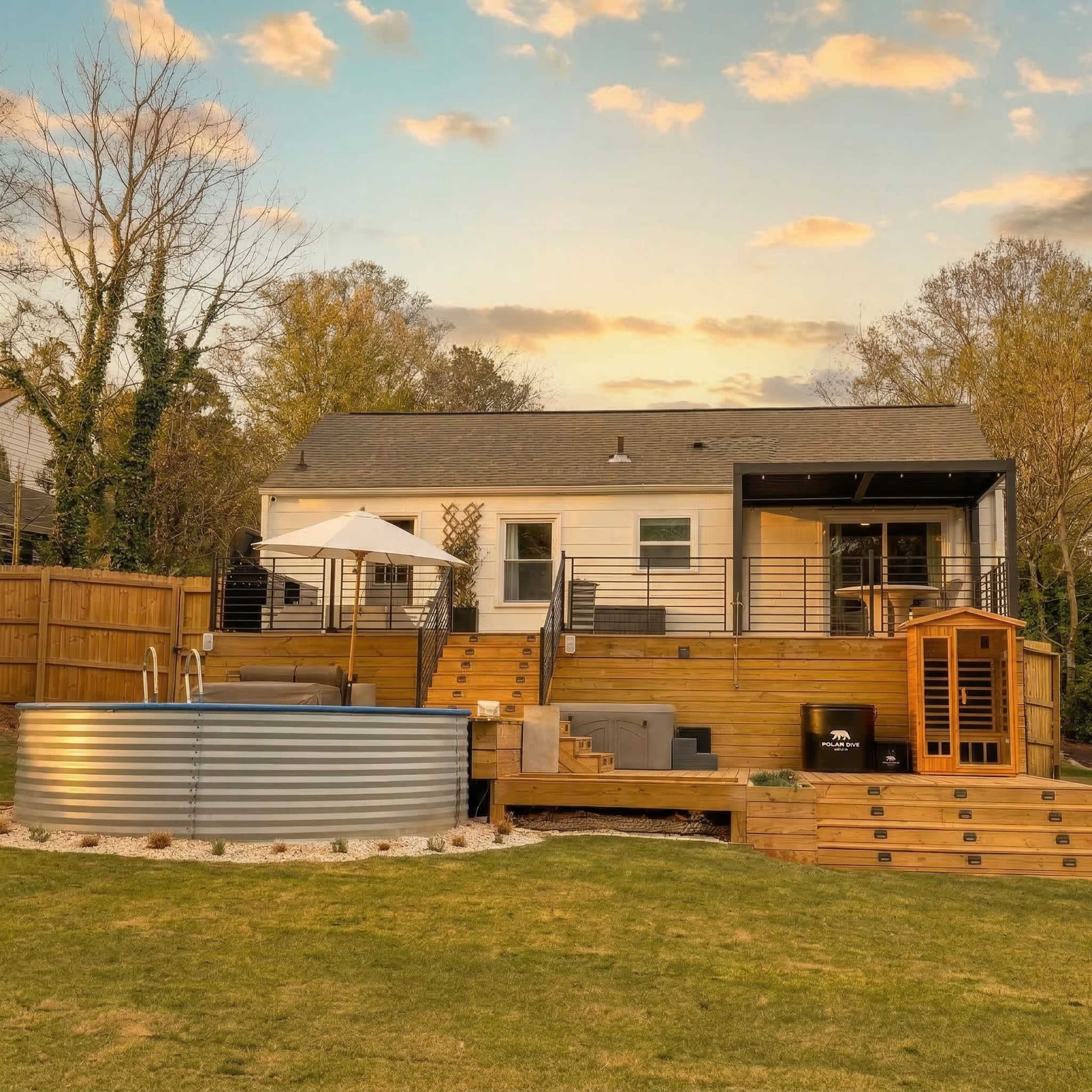 The image shows a backyard with a modern house featuring a deck, a above-ground pool, and a sauna, all set against a backdrop of trees and a cloudy sky.