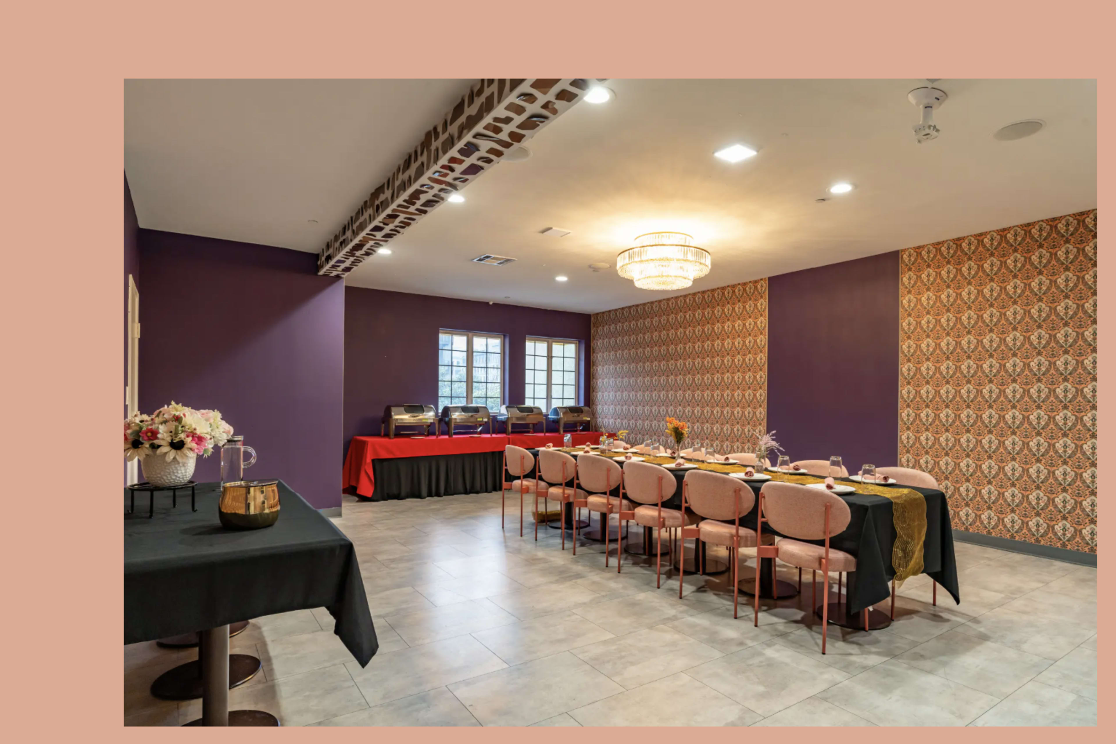 A dining area features rows of chairs and tables set up for an event, with textured walls and decorative lighting.