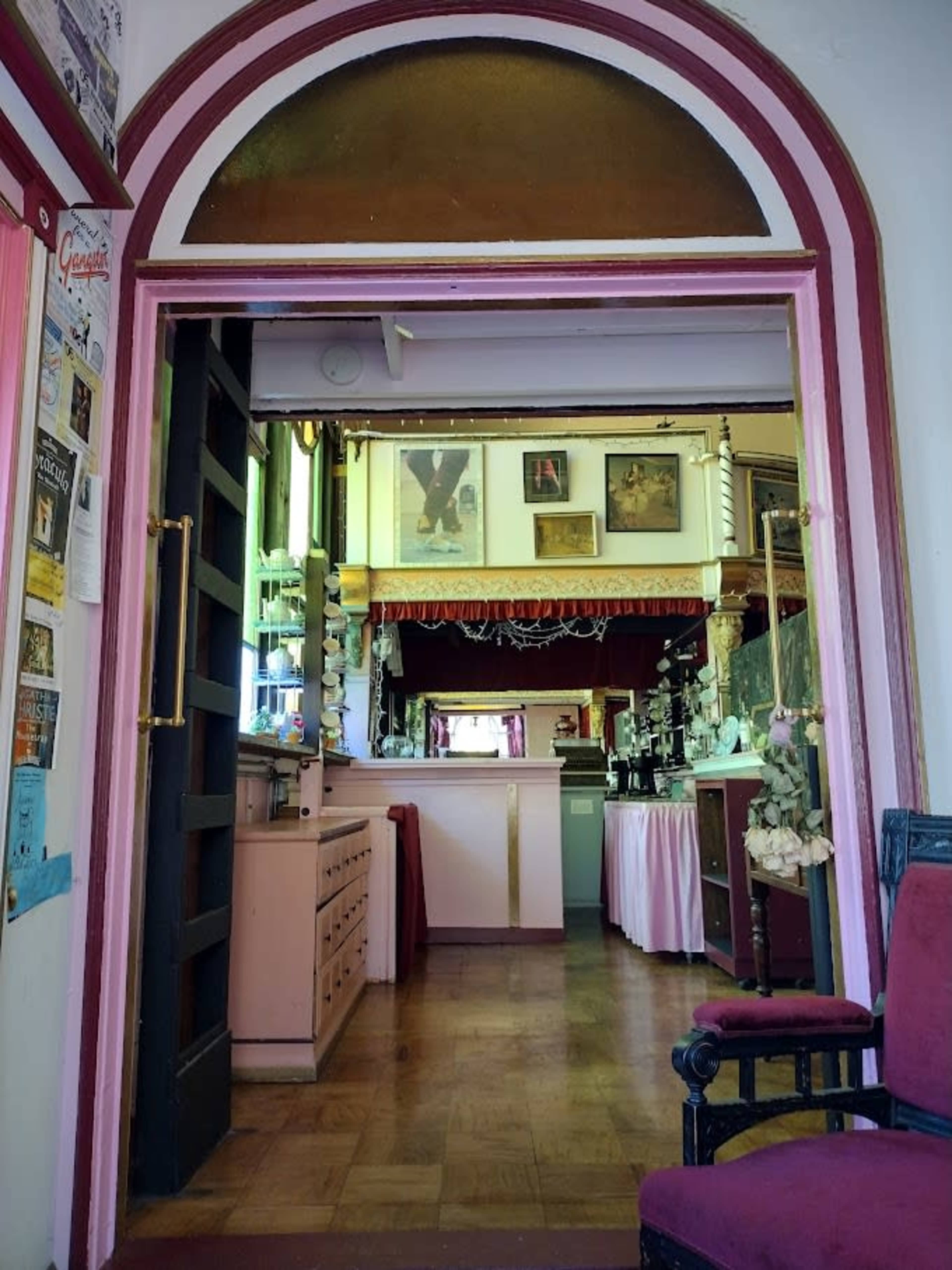 The image shows a doorway leading into a room with a visible bar area, decorated walls, and various framed pictures.