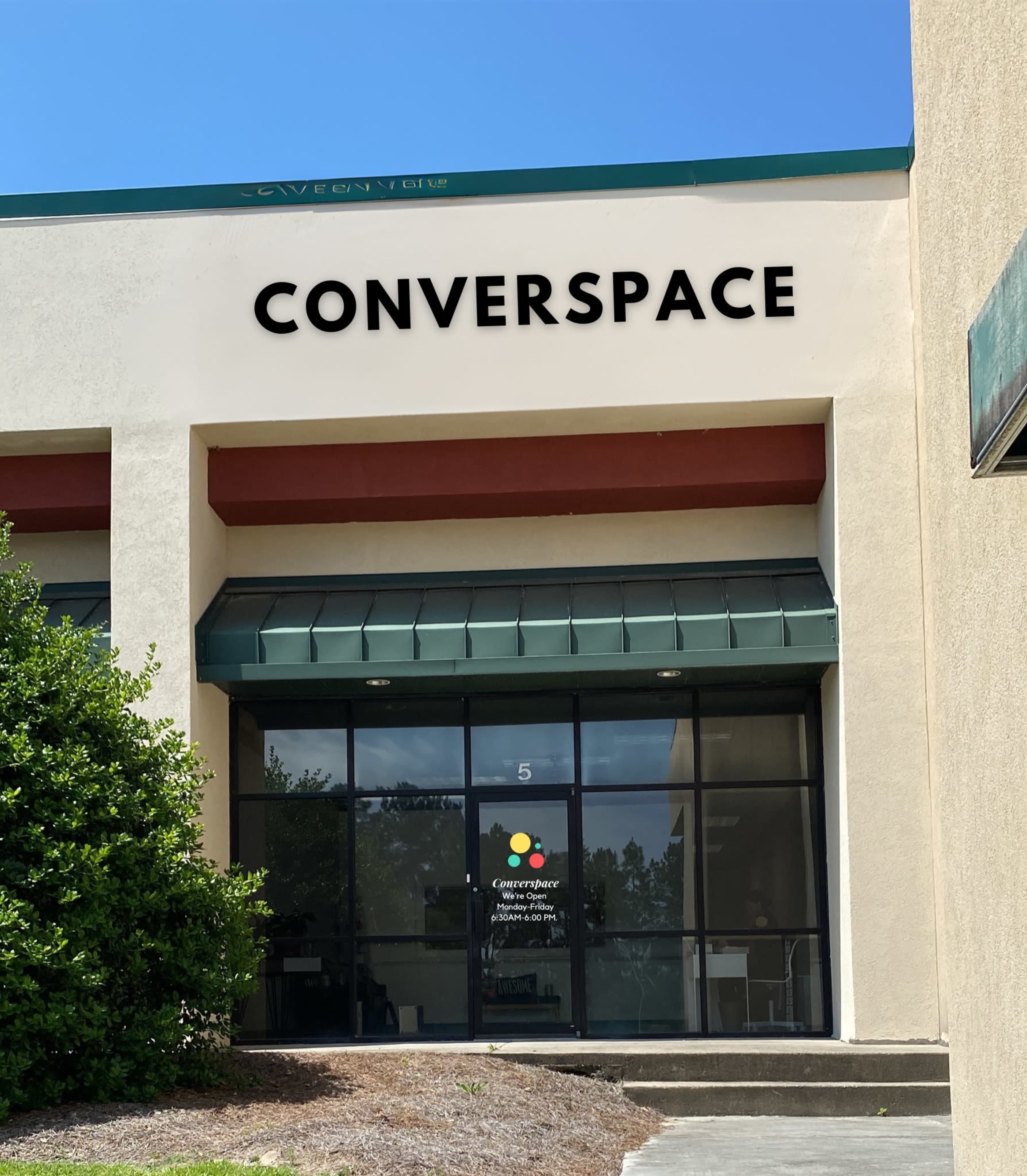 The image shows a business front with the sign "CONVERSPACE" above the entrance and a colorful logo in the window.