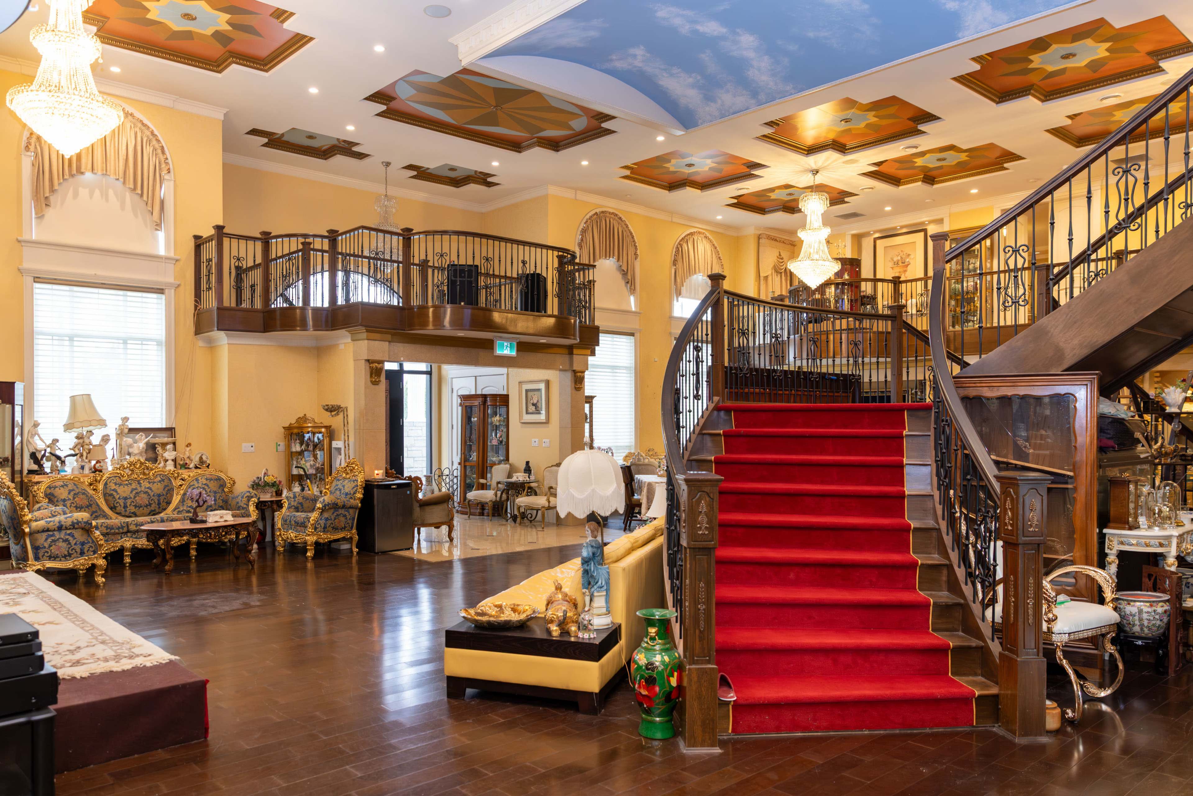 The image showcases a luxurious interior with a grand staircase, ornate furnishings, and intricate ceiling designs.