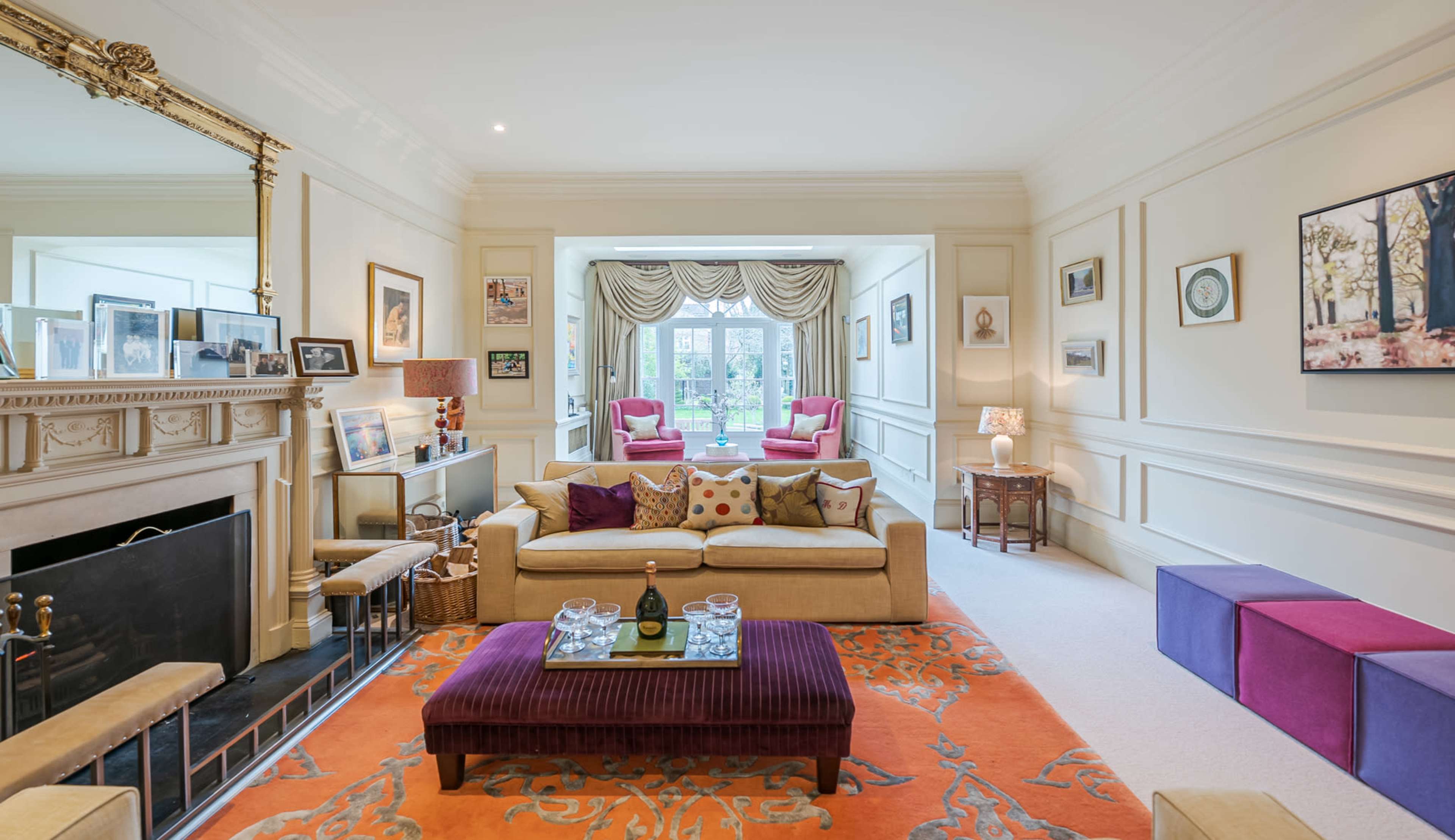 A well-furnished living room with a sofa, a decorative coffee table, and large windows that open to a garden view.