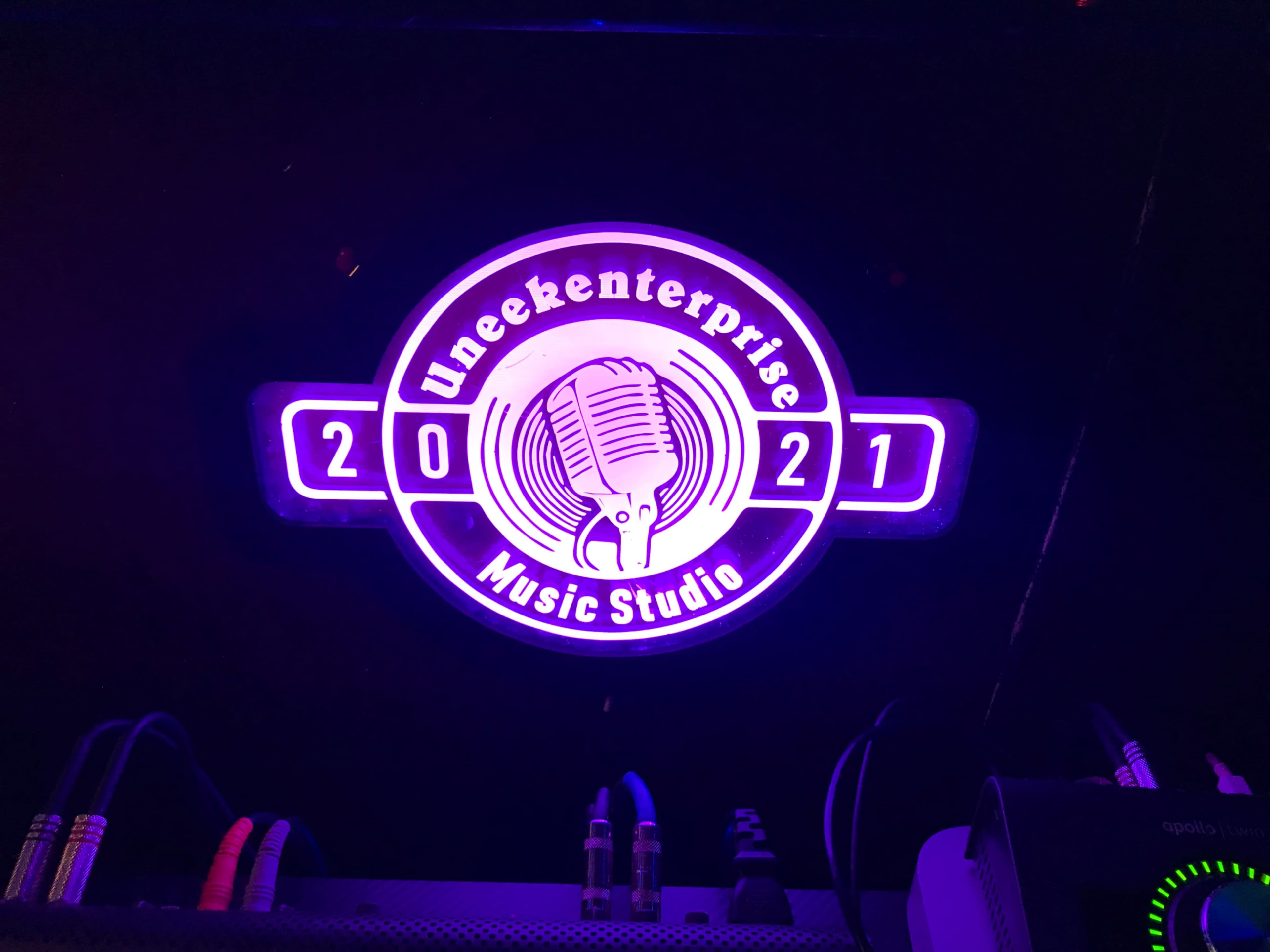 The image features a neon-lit circular logo for "Uneekenterprise Music Studio," with the year "2021" prominently displayed.