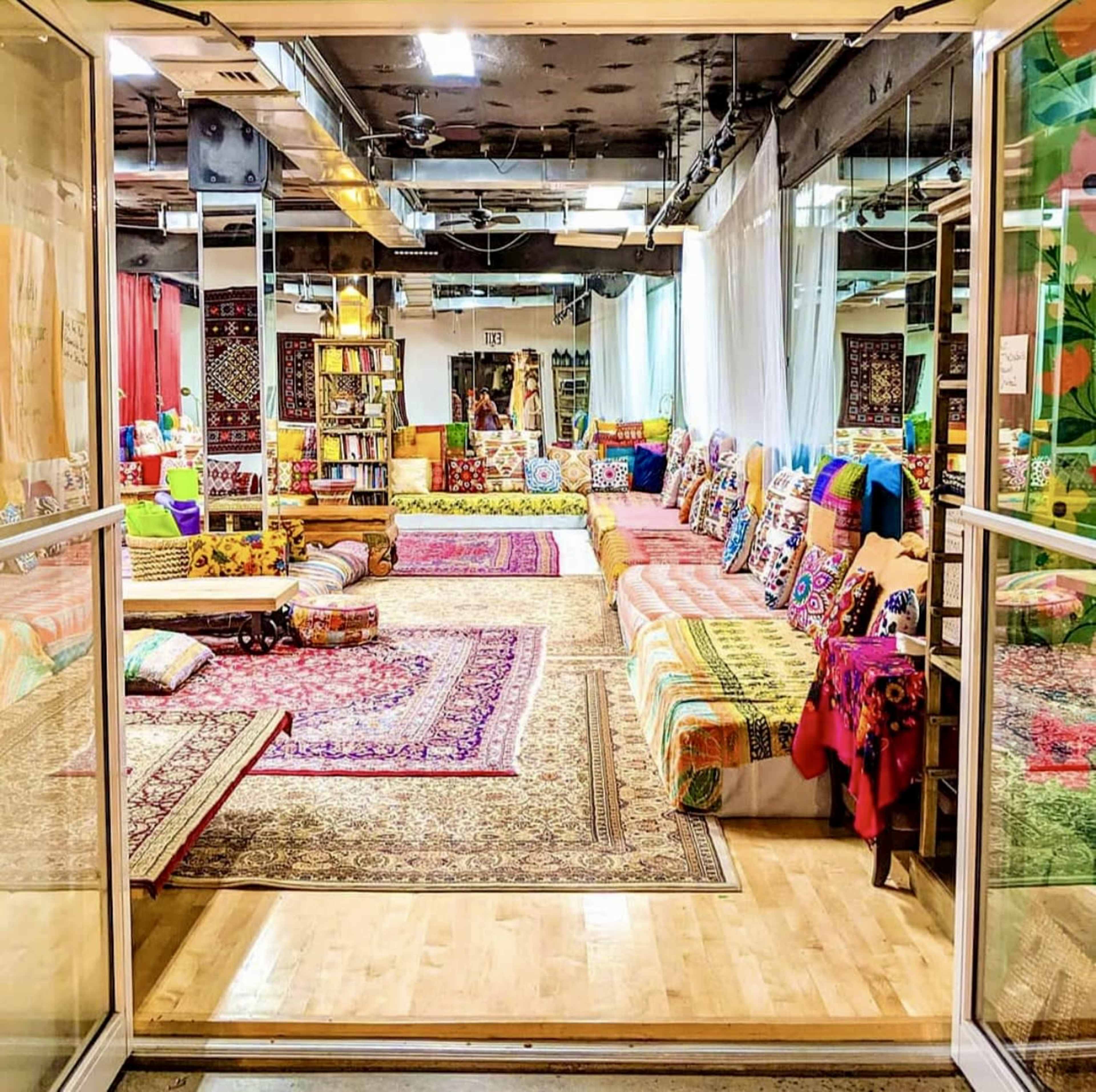 A brightly decorated communal space with an array of colorful pillows and rugs, arranged for seating and relaxation.