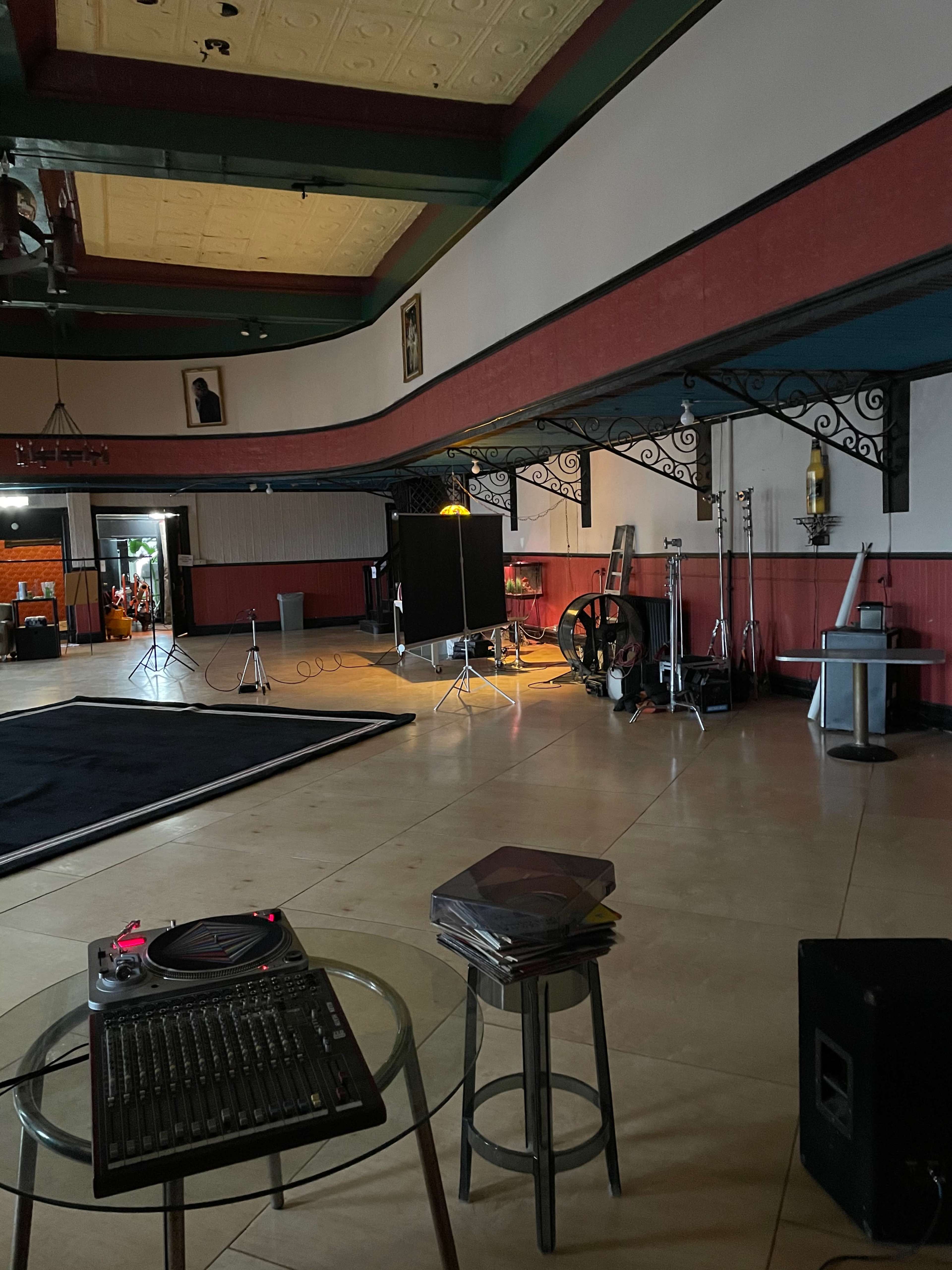 A spacious interior of a studio or stage area with music equipment, lighting setups, and decorative elements along the walls.