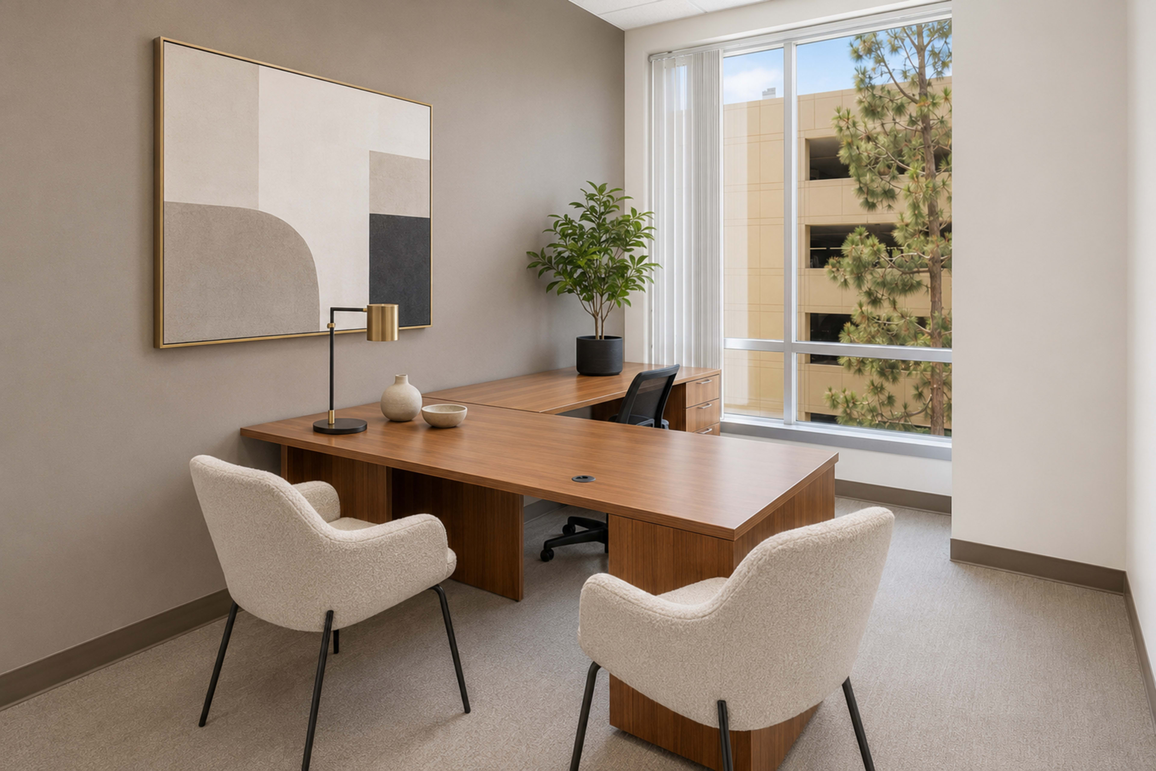 The image shows a minimalistic office space featuring a wooden desk, two upholstered chairs, a potted plant, and a large window with a view of a building exterior.