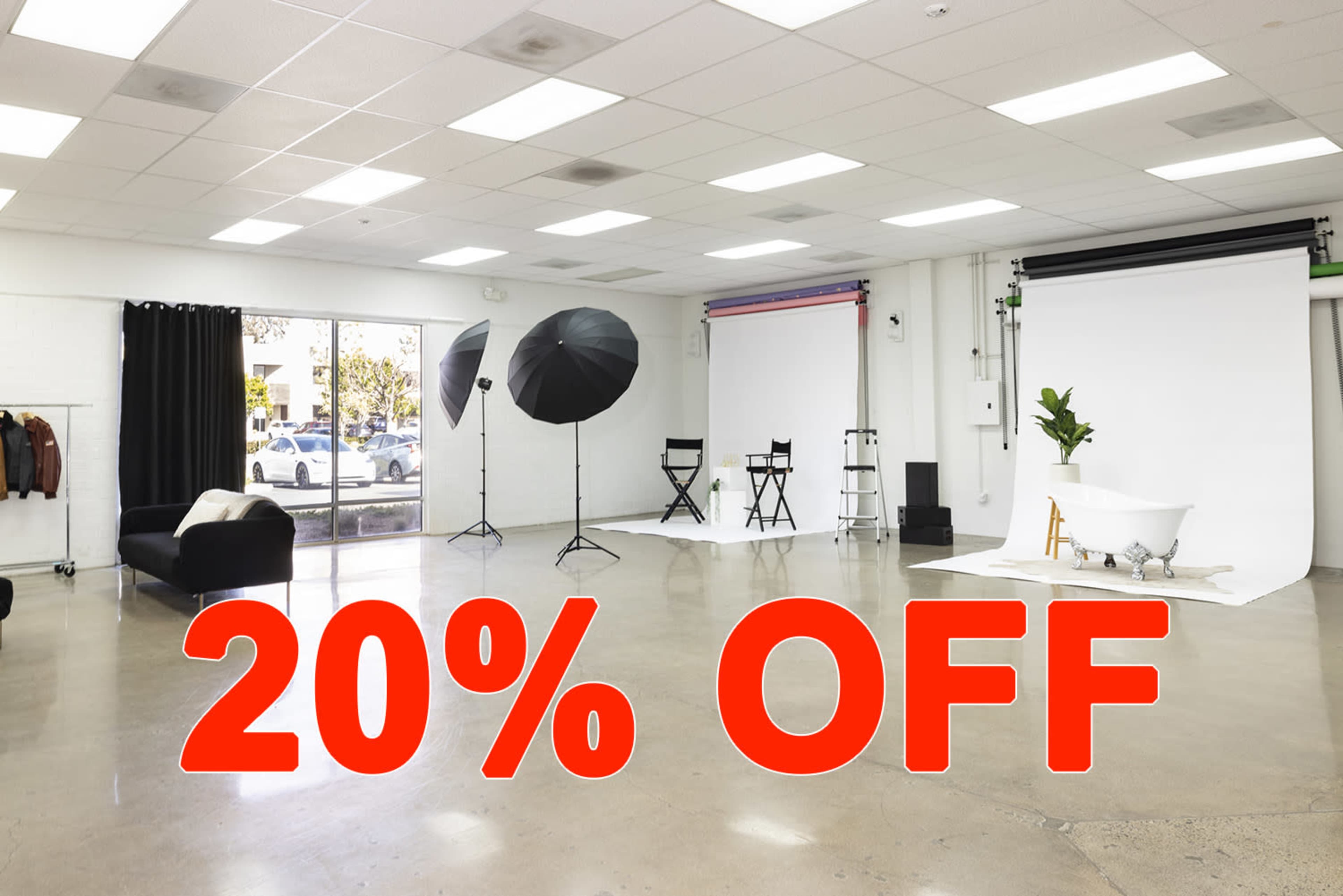 A spacious photo studio features various backdrops, lighting equipment, and a marked discount offer of 20% off.