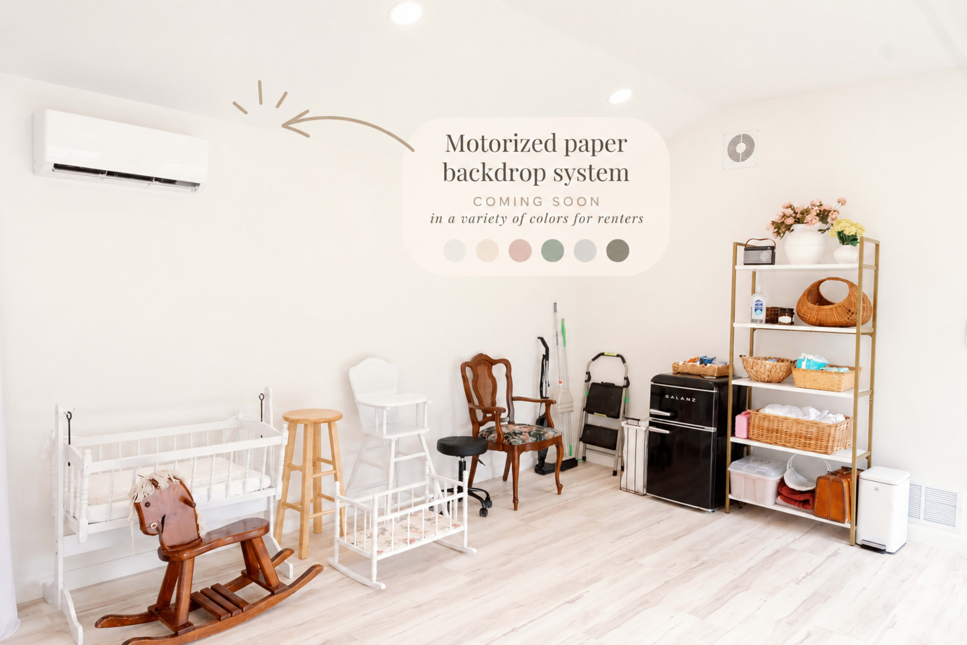 The image depicts a well-organized room featuring various types of furniture, including a rocking horse, chairs, a small fridge, and storage units, with a sign indicating a motorized paper backdrop system.