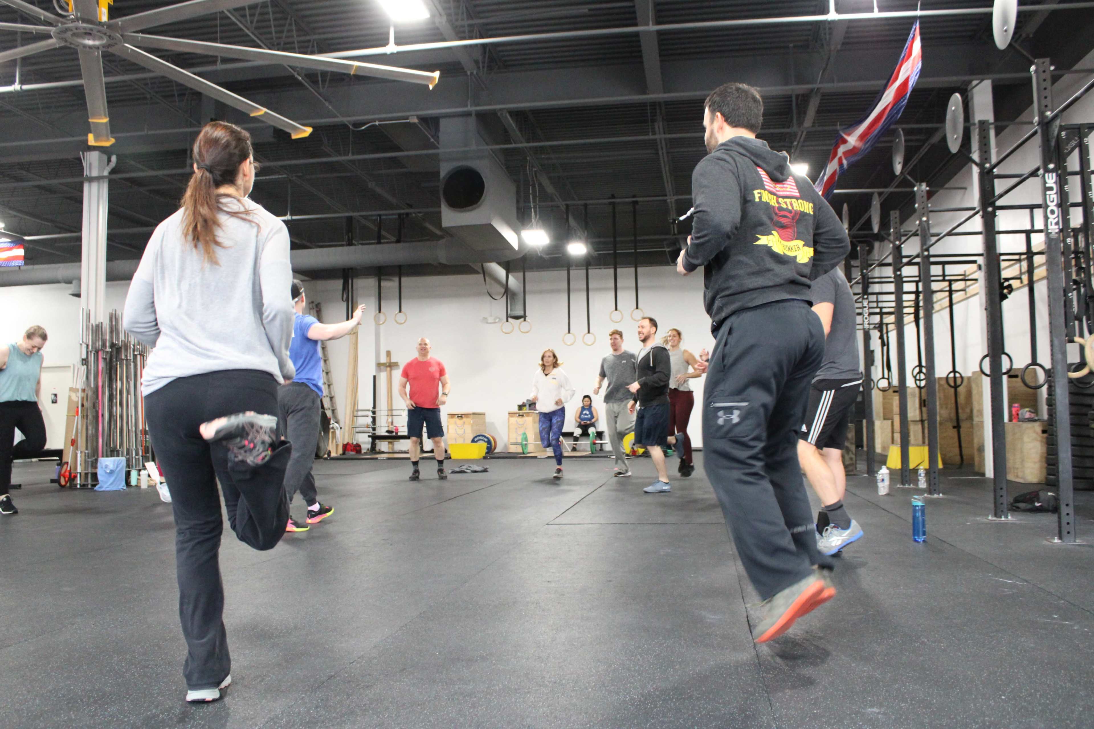 A group of people is exercising in a gym, participating in a workout session.