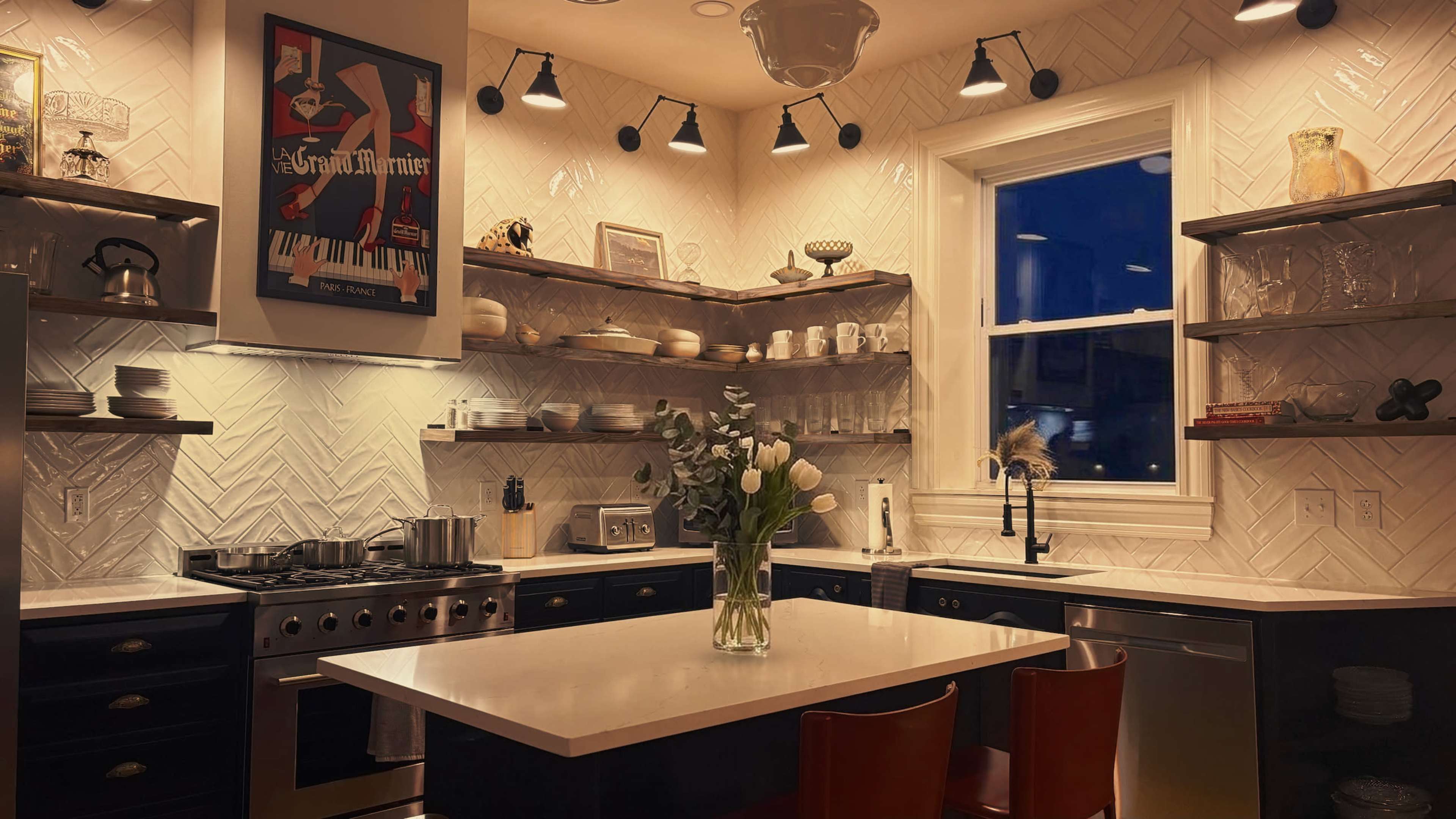 The image depicts a modern kitchen with black cabinetry, white countertops, and open shelves displaying dishware, illuminated by warm lighting.