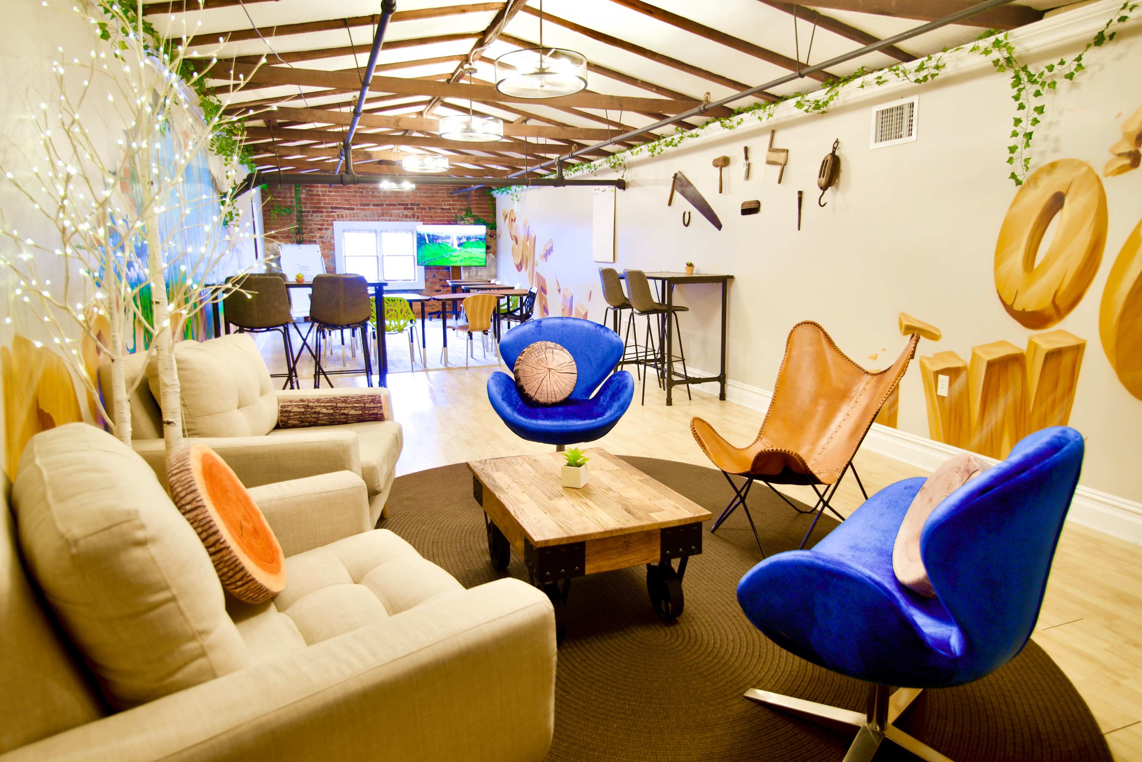 A modern, open space with comfortable seating, a wooden coffee table, and a bright mural on the wall.