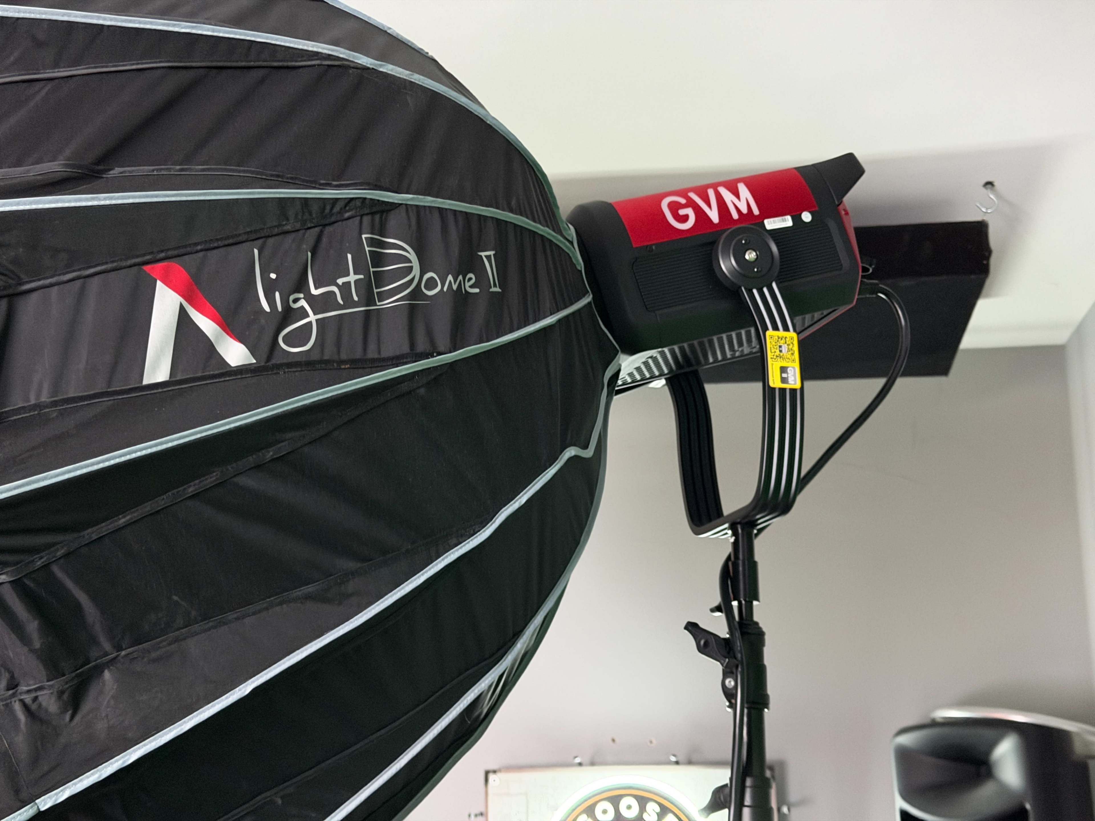 The image shows a photography lighting setup featuring a Light Dome II softbox attached to a GVM light mounted on a stand.