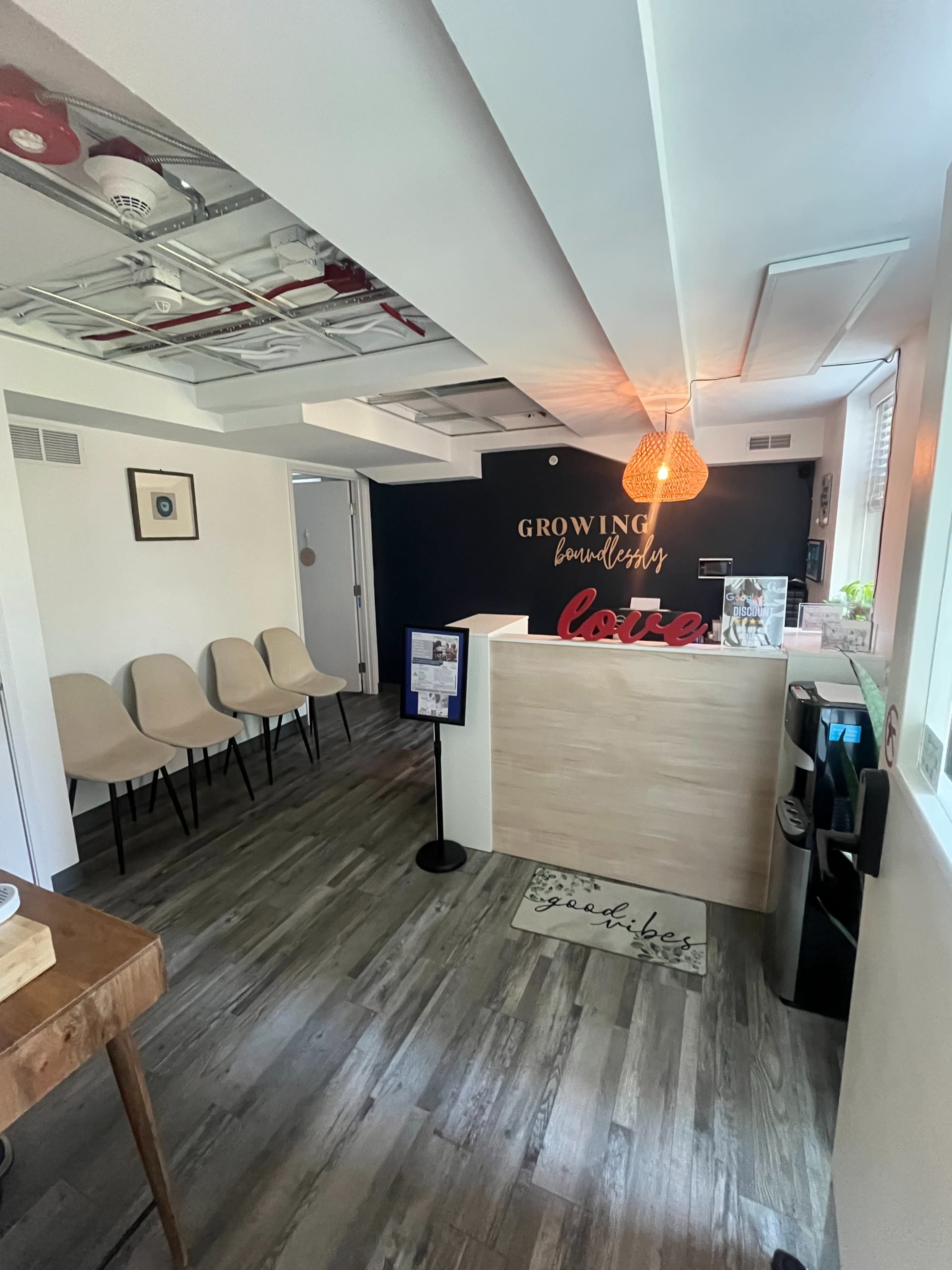 A modern reception area with a front desk, seating for visitors, and a decorative wall sign that reads "Growing."