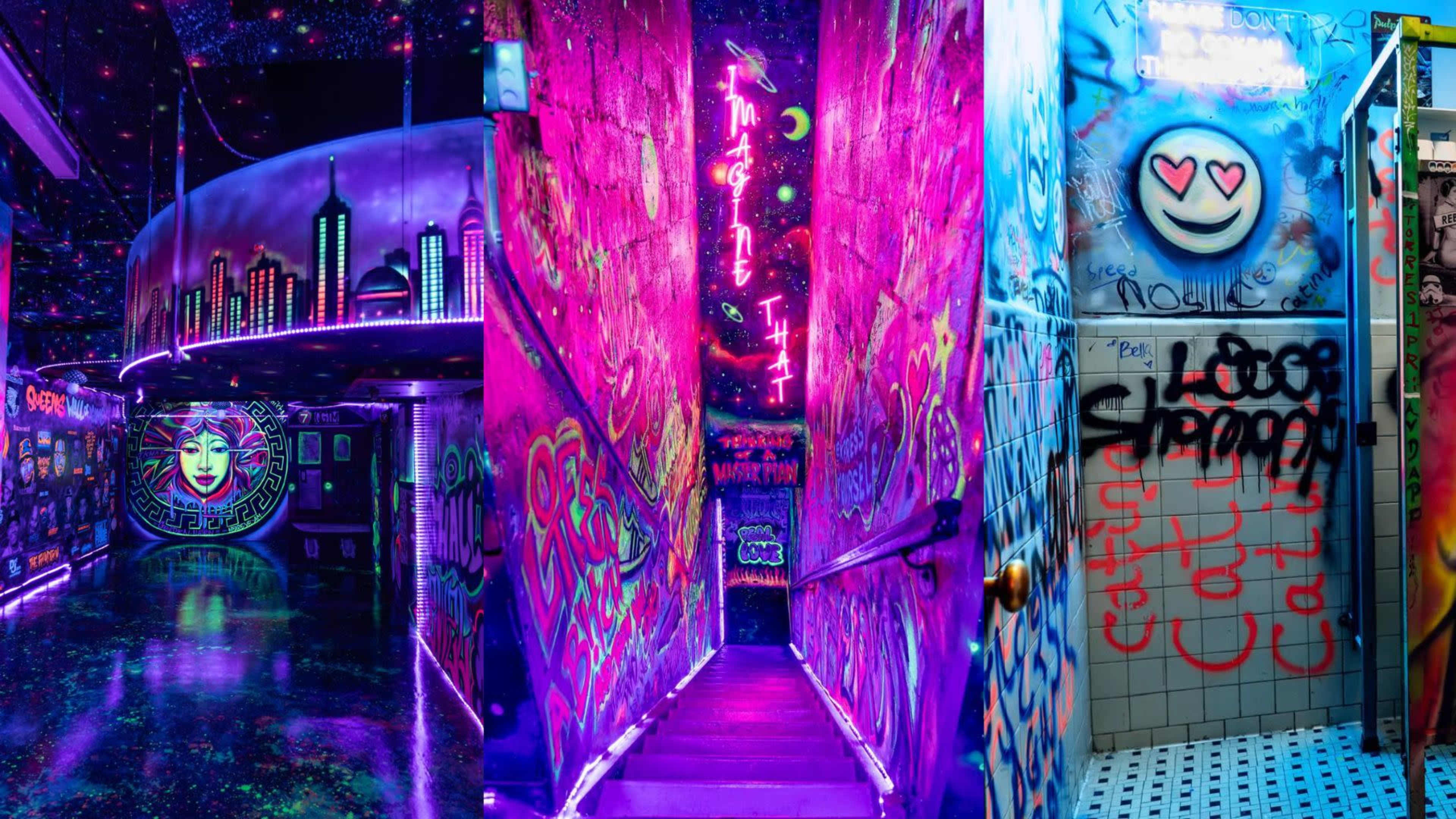 A vibrant, graffiti-covered hallway illuminated by neon lights, leading down a set of stairs.
