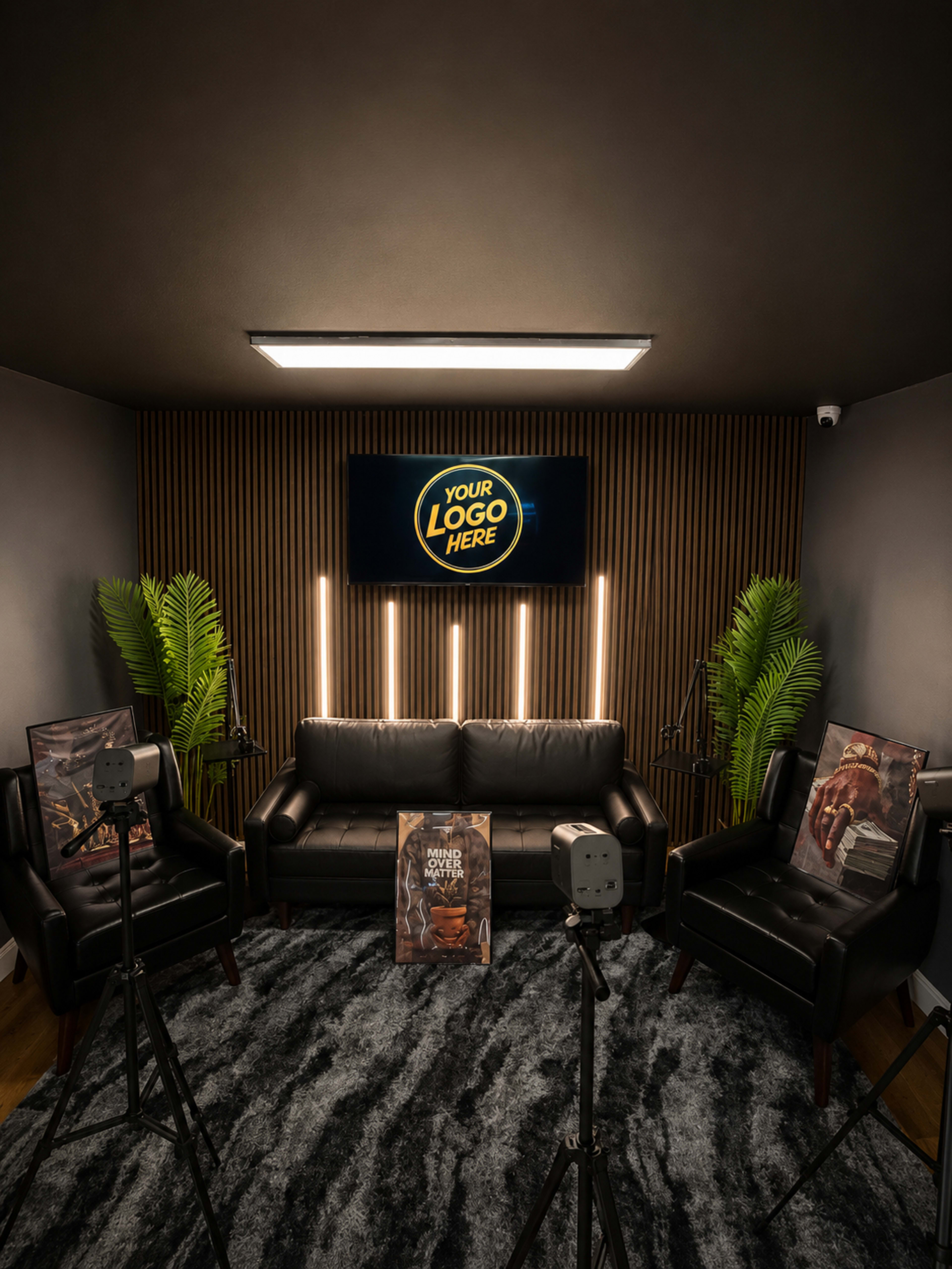 The image shows a modern interview setup featuring a black leather sofa, illuminated by vertical lights against a wood-paneled wall, with two cameras positioned on tripods facing the seating area.