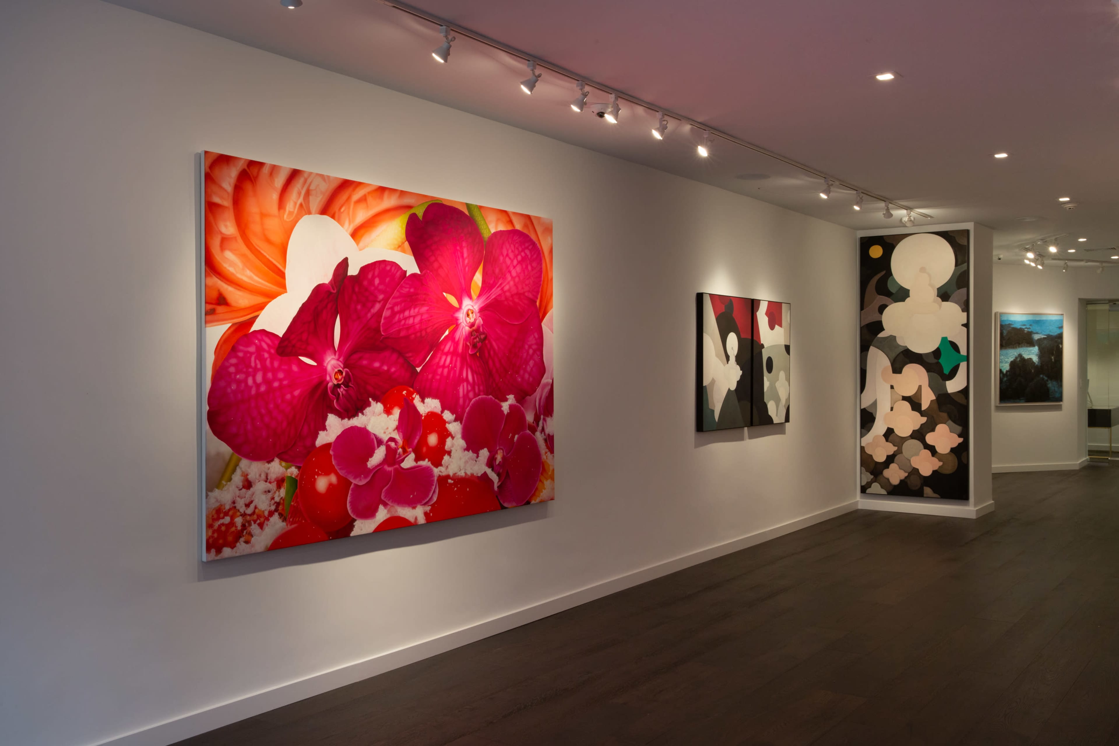 A contemporary art gallery featuring large, colorful floral paintings on the walls.