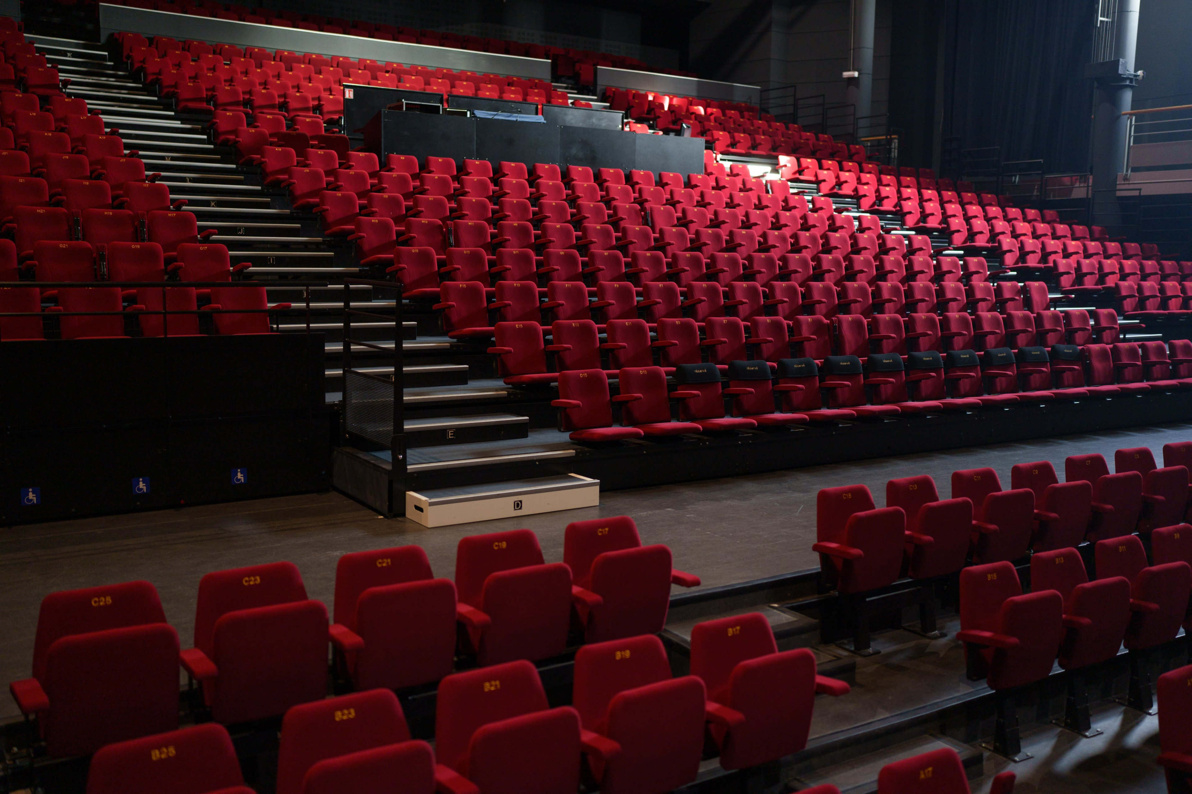 A spacious theater filled with red upholstered seats arranged in a tiered formation.