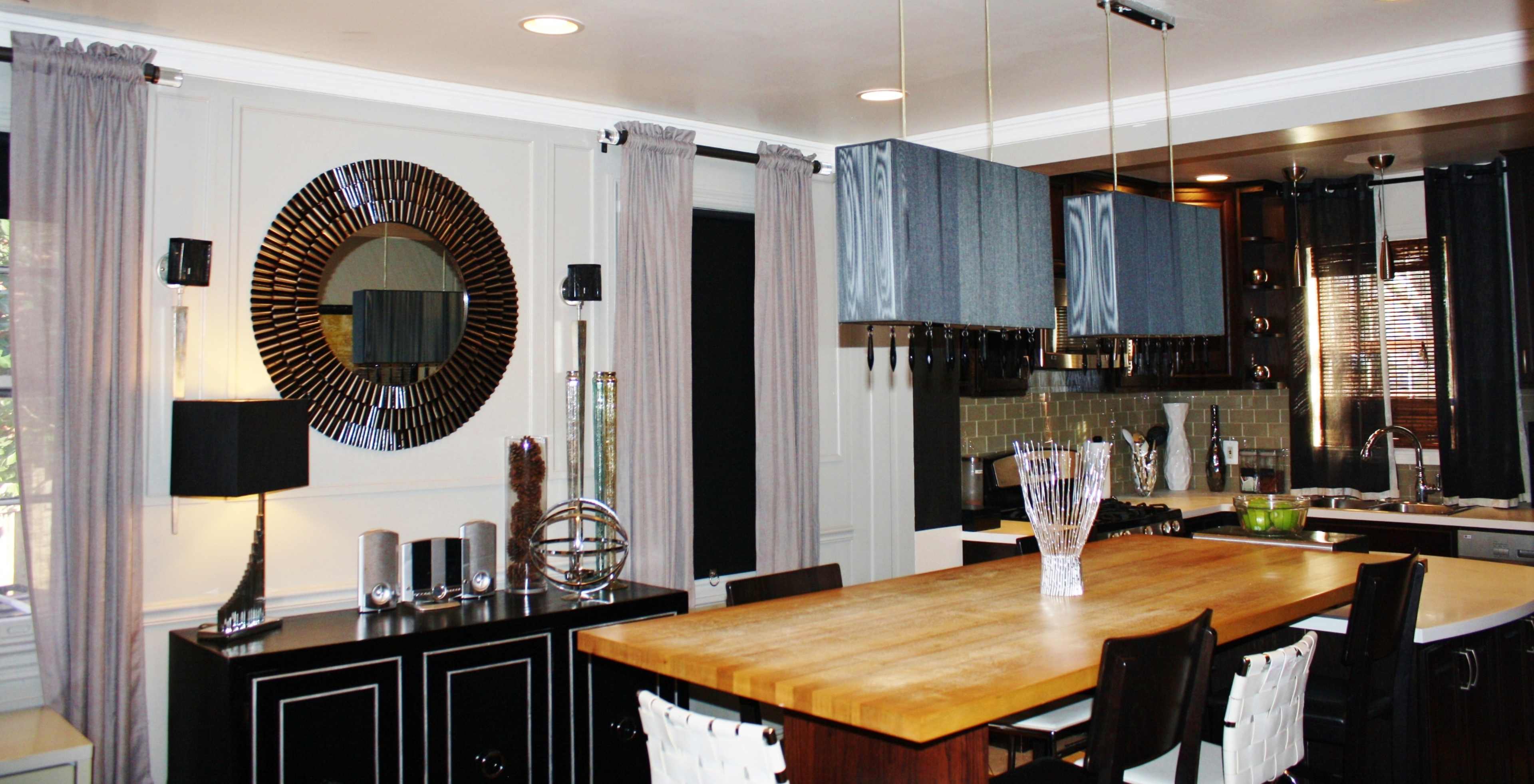 A modern kitchen features an island with a wooden countertop, blue cabinets, and decorative elements on the walls.