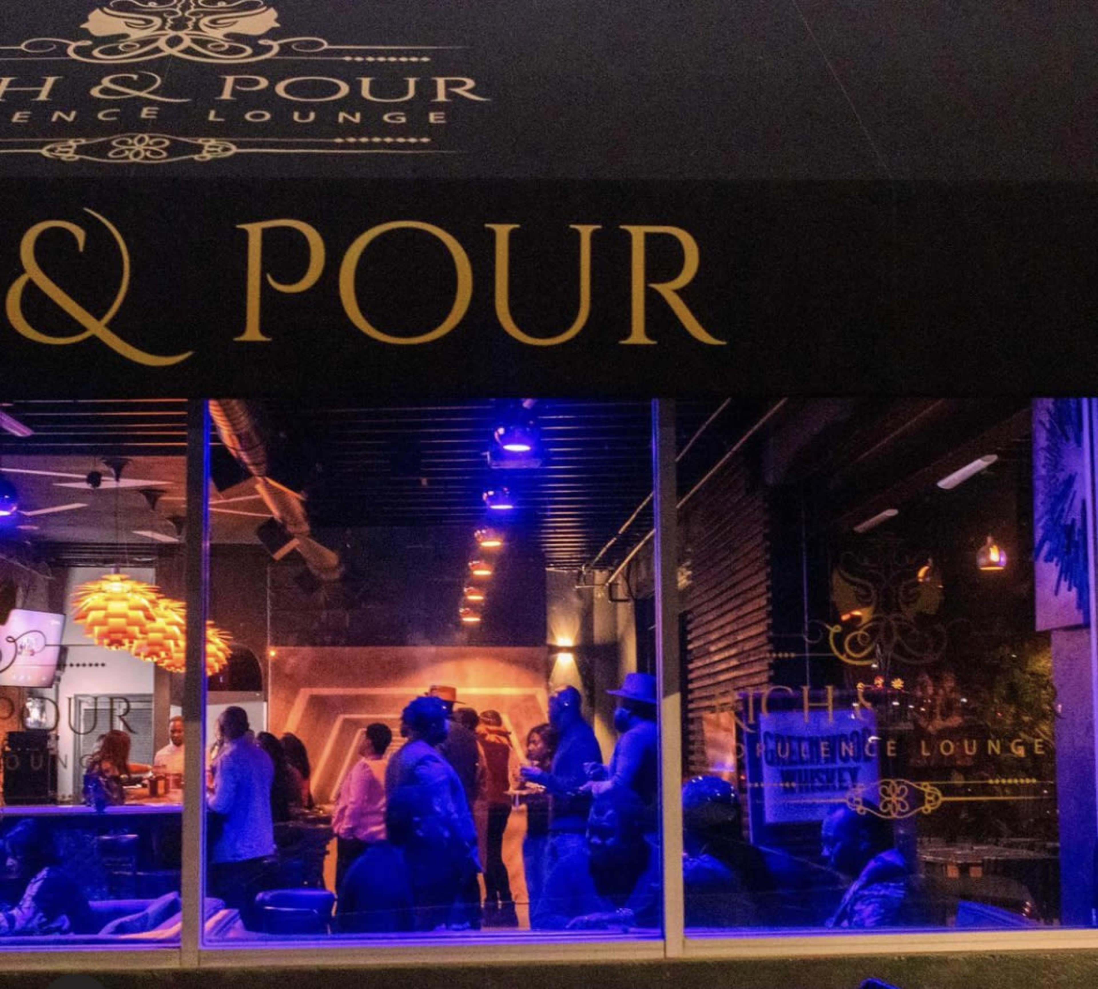 The image shows a lively lounge scene with patrons socializing under dim lighting and blue accents.