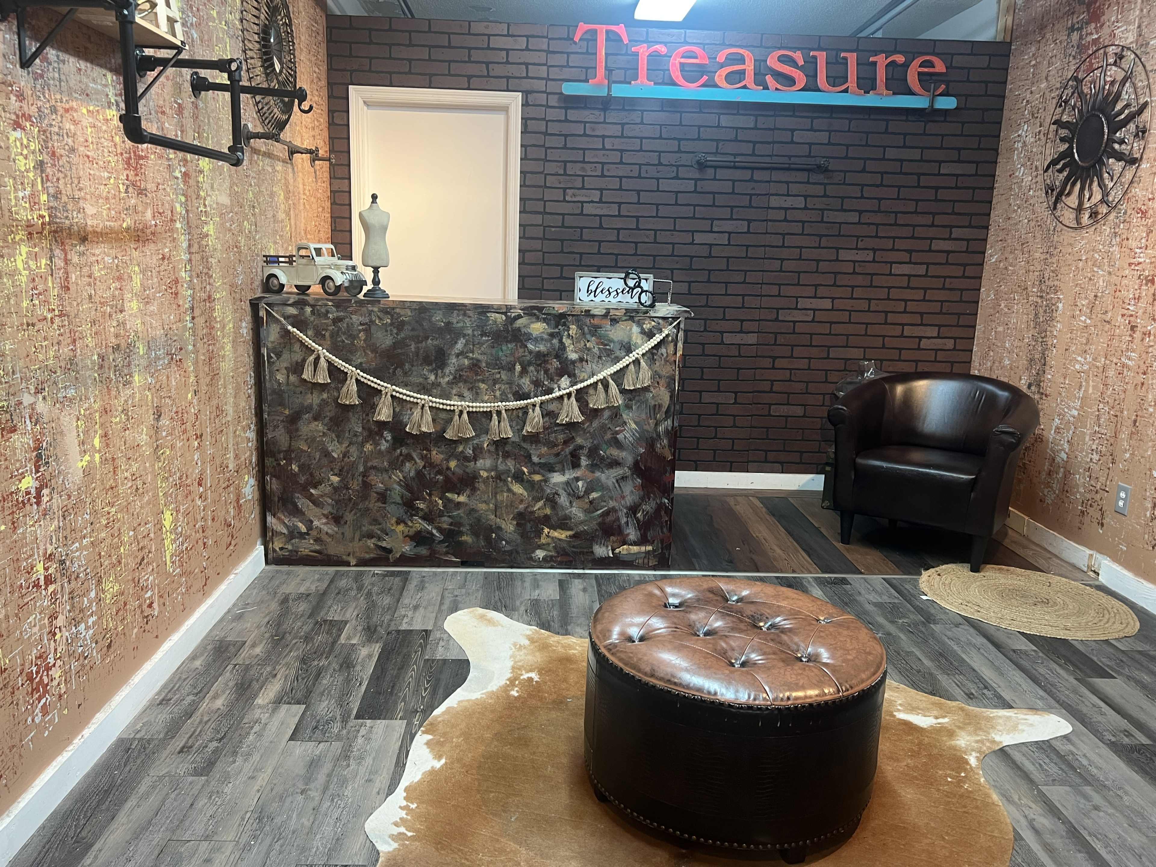 The image shows a small retail space with a reception area featuring a decorative counter, a chair, and a decorative faux cowhide rug on the floor.