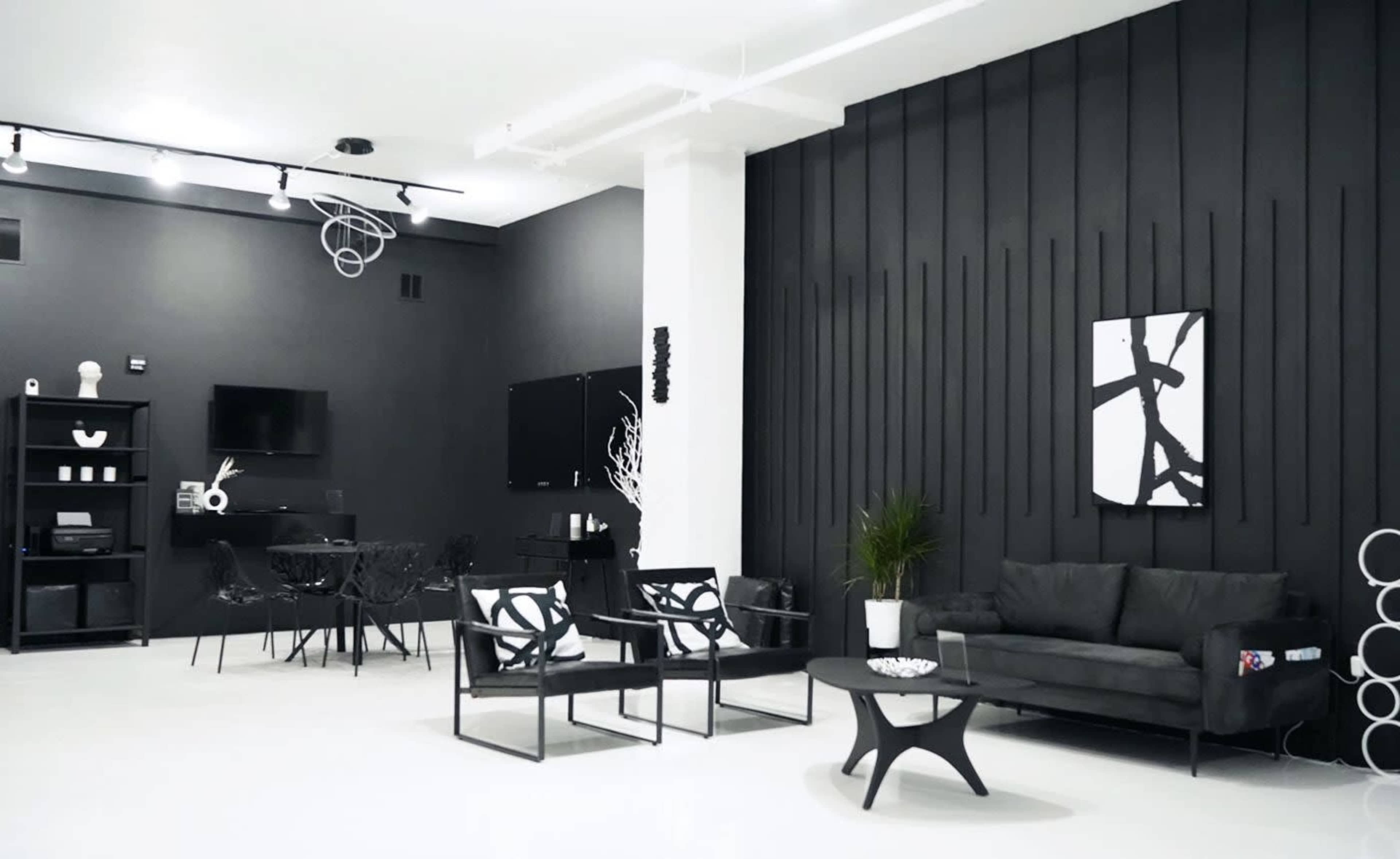 A modern interior space with black walls, white furniture, and minimalist decor.