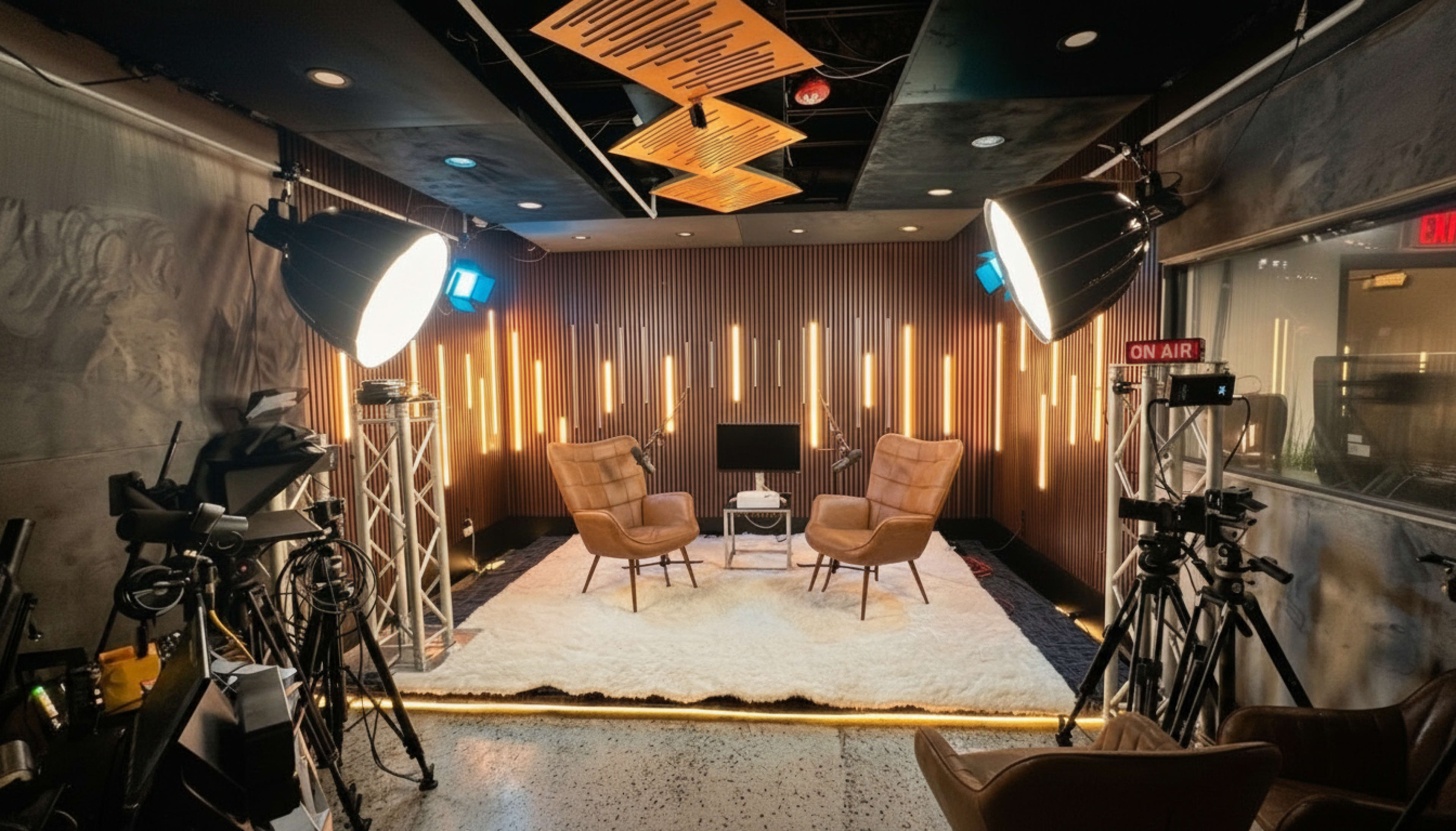 The image shows a modern studio setup with two brown chairs, a small table between them, and multiple lighting fixtures, all positioned against a wooden accent wall with illuminated vertical strips.
