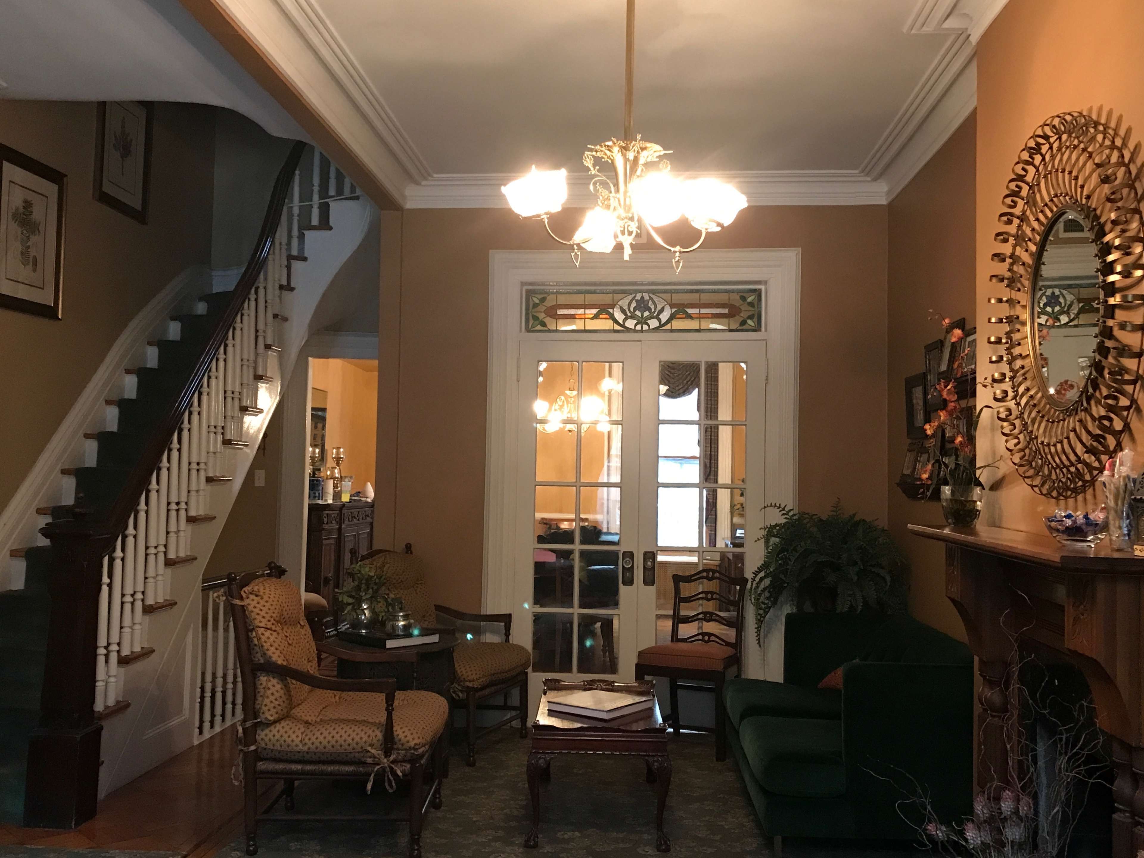 A well-furnished entryway with a staircase, seating areas, and decorative elements.