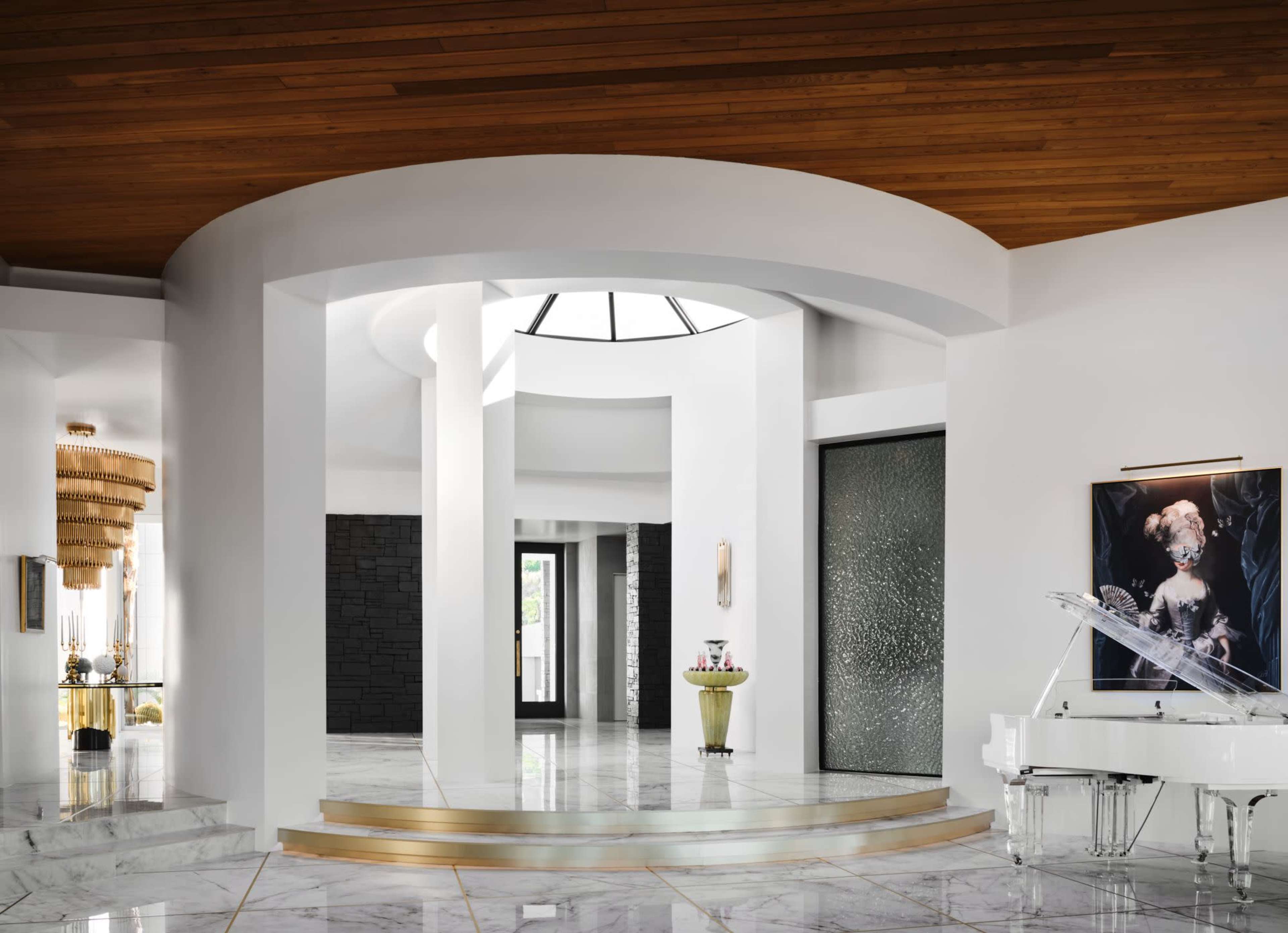 The image shows a modern entryway with a high ceiling, marble floors, and a grand piano positioned beside a large decorative painting.