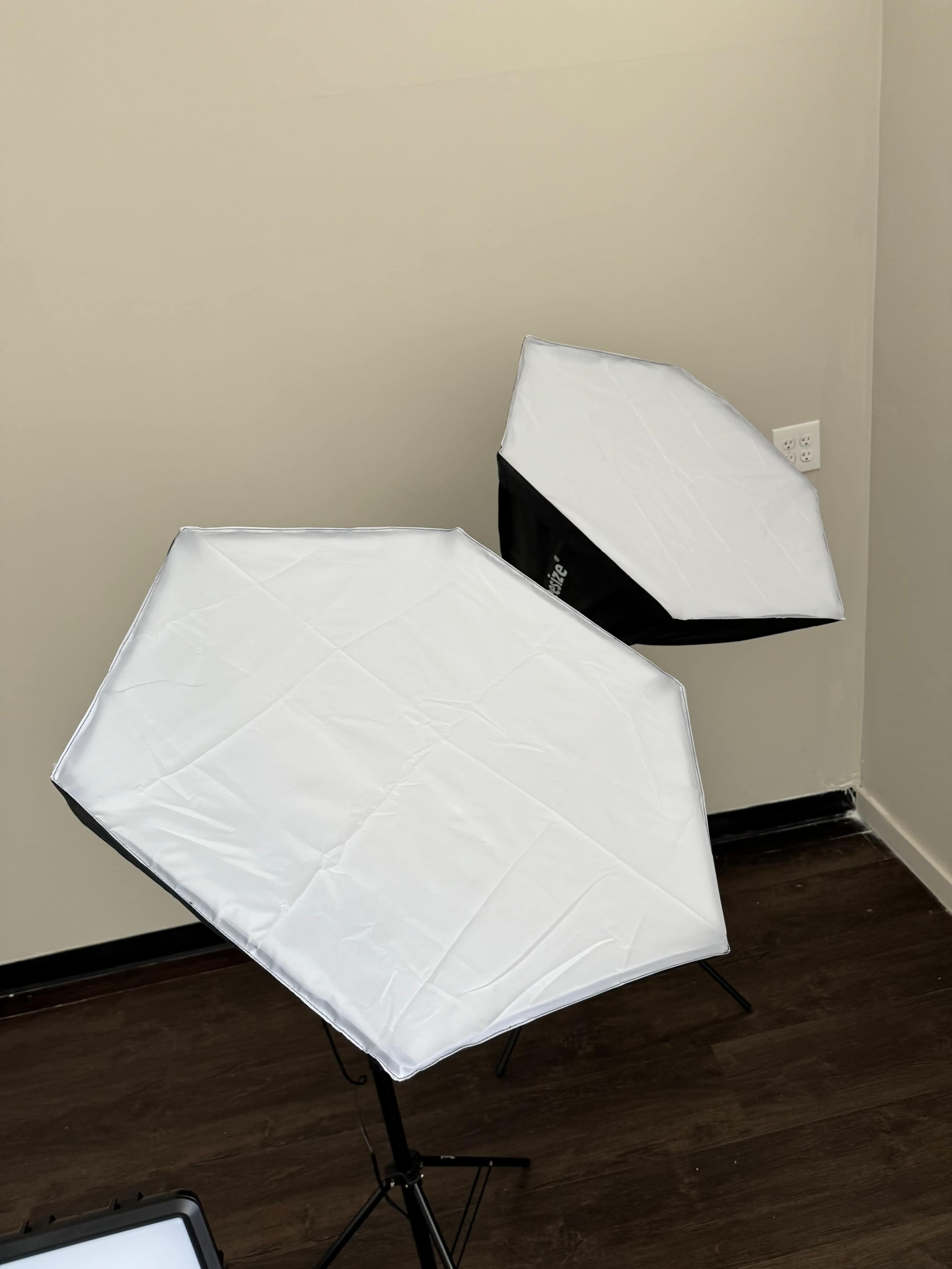 Two softbox light modifiers set up in a corner of a room.