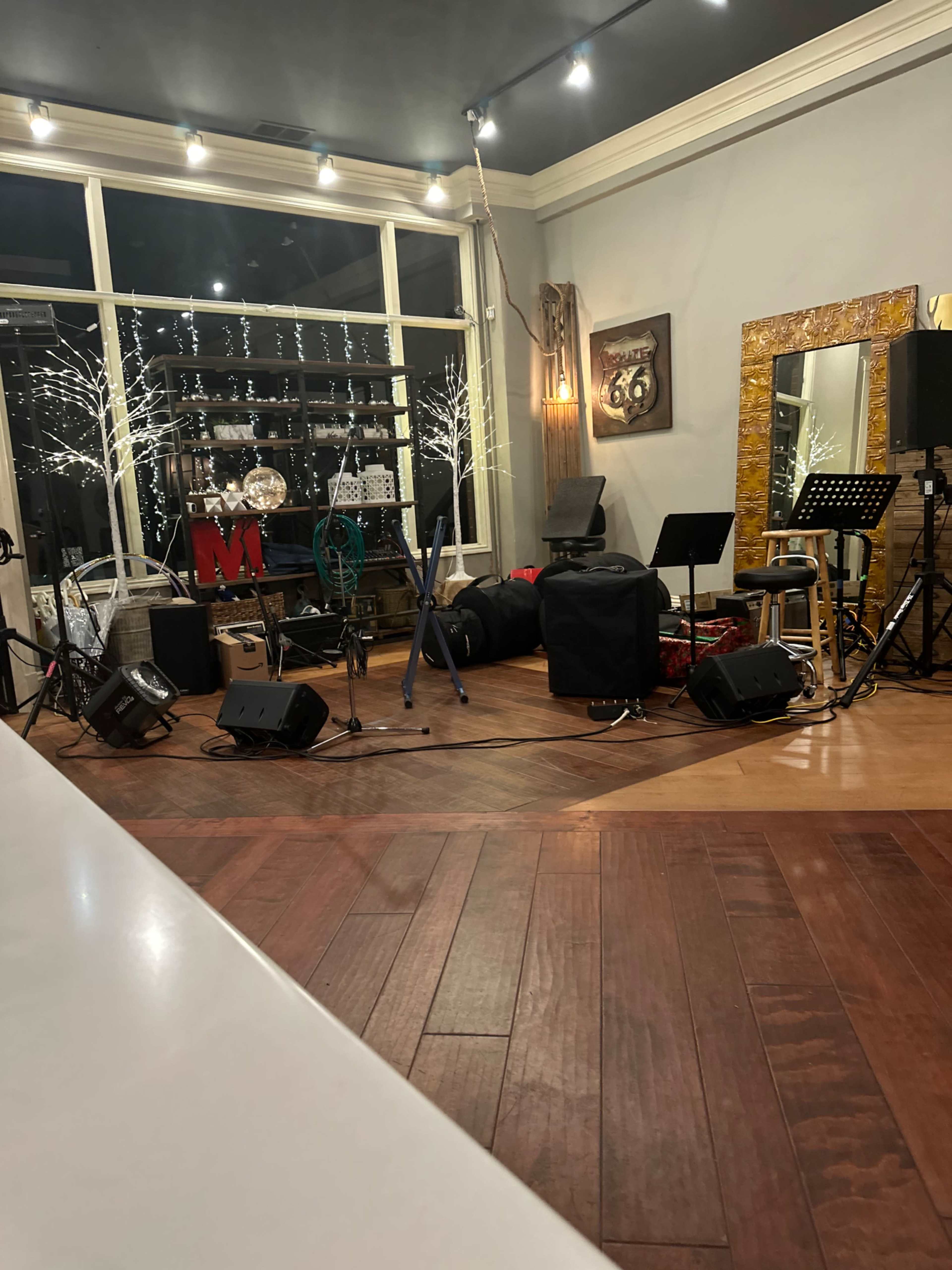 A performance space with musical instruments, microphones, and decor, including lights and a large mirror.
