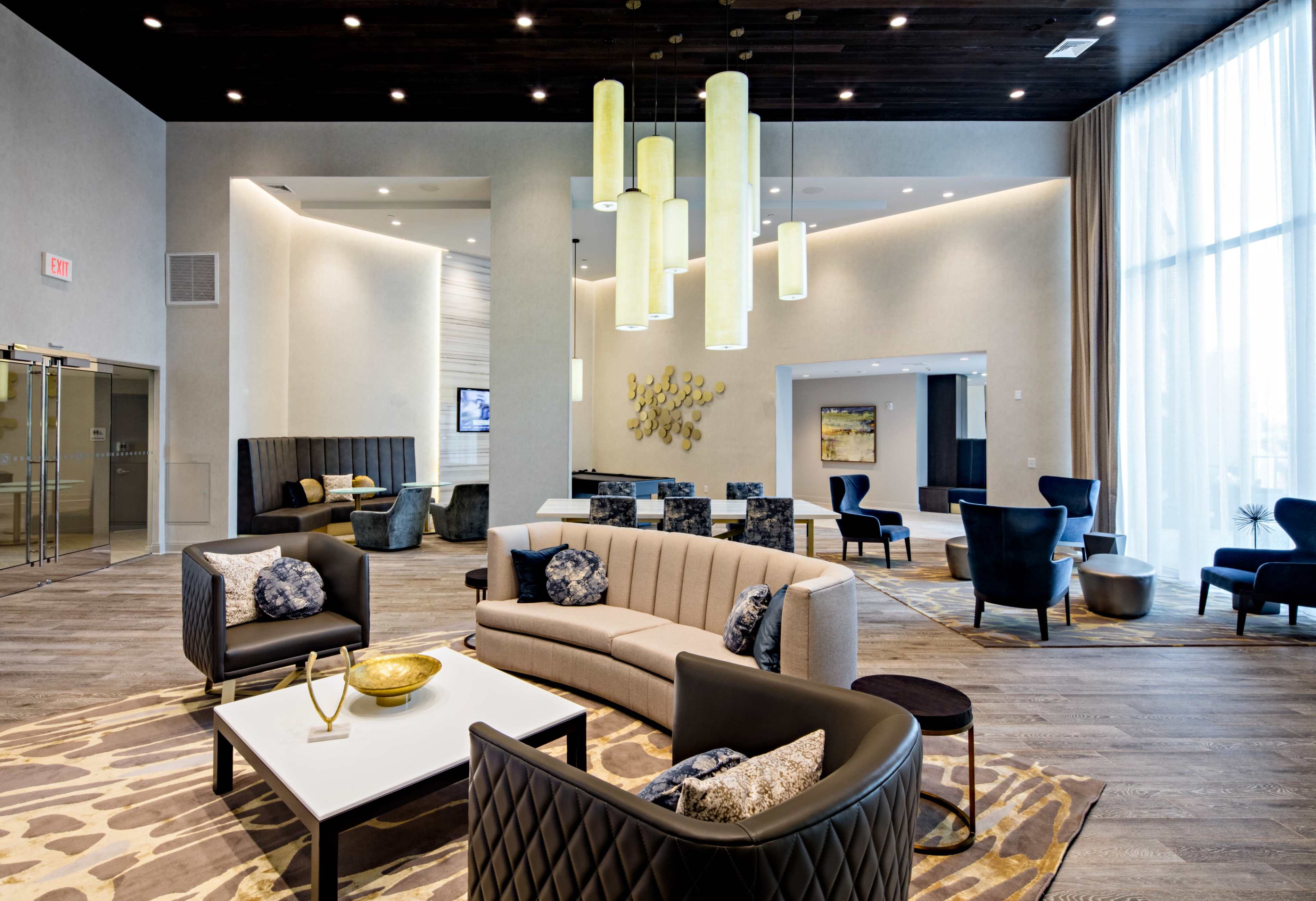 A modern lounge area with stylish seating, a large light fixture, and contemporary decor.
