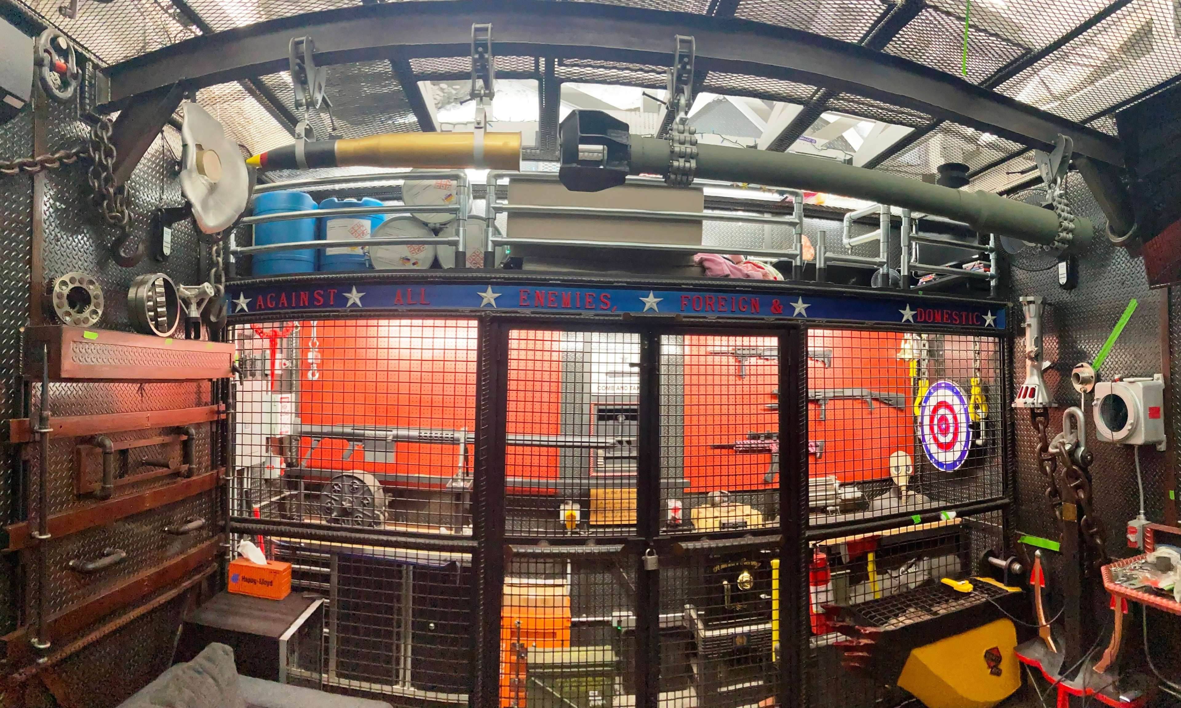 The image shows a workshop or storage area filled with various tools, equipment, and a distinctive, large cylindrical object mounted on the wall.
