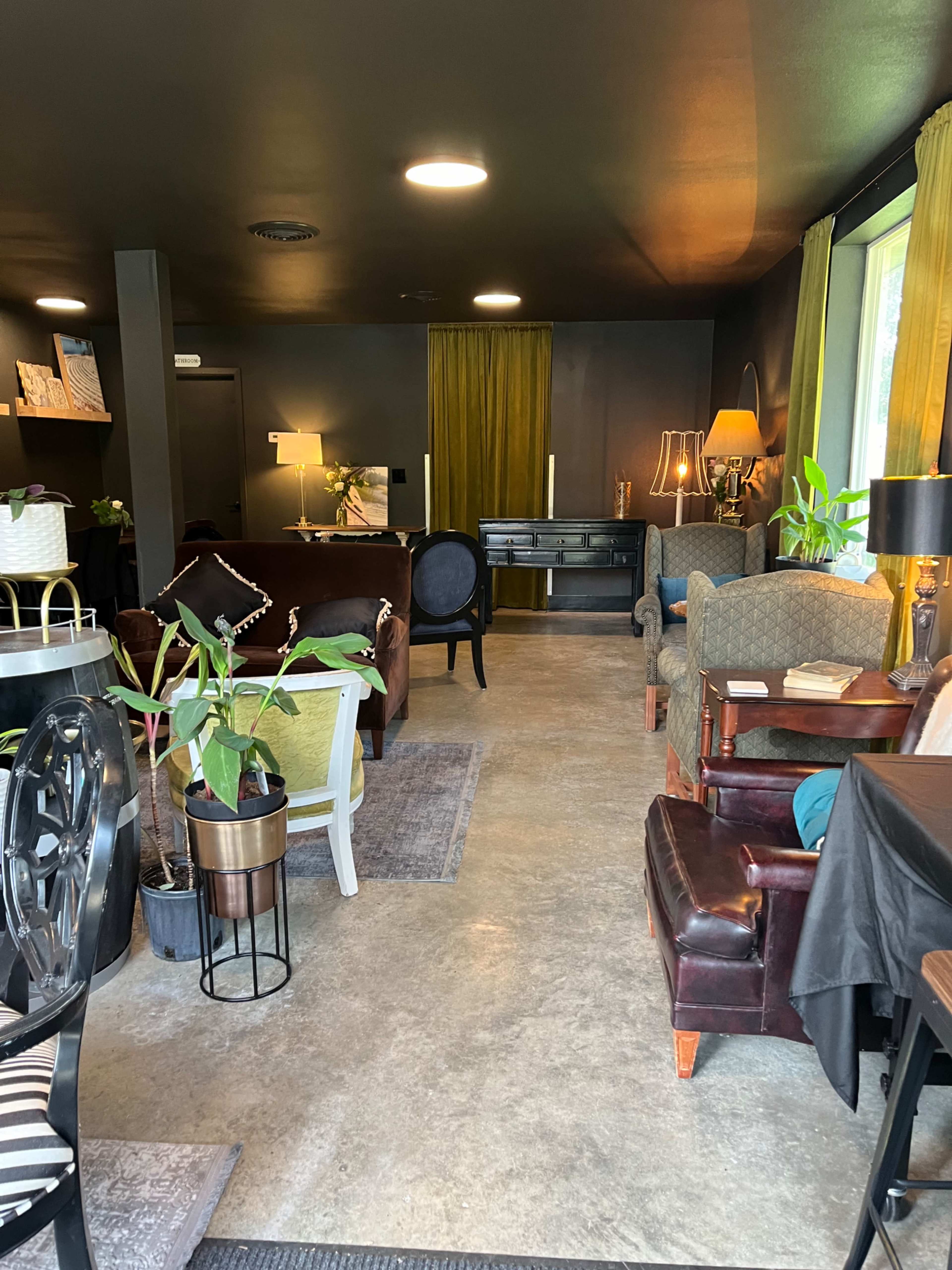 A cozy lounge area featuring various seating arrangements, plants, and warm lighting elements.