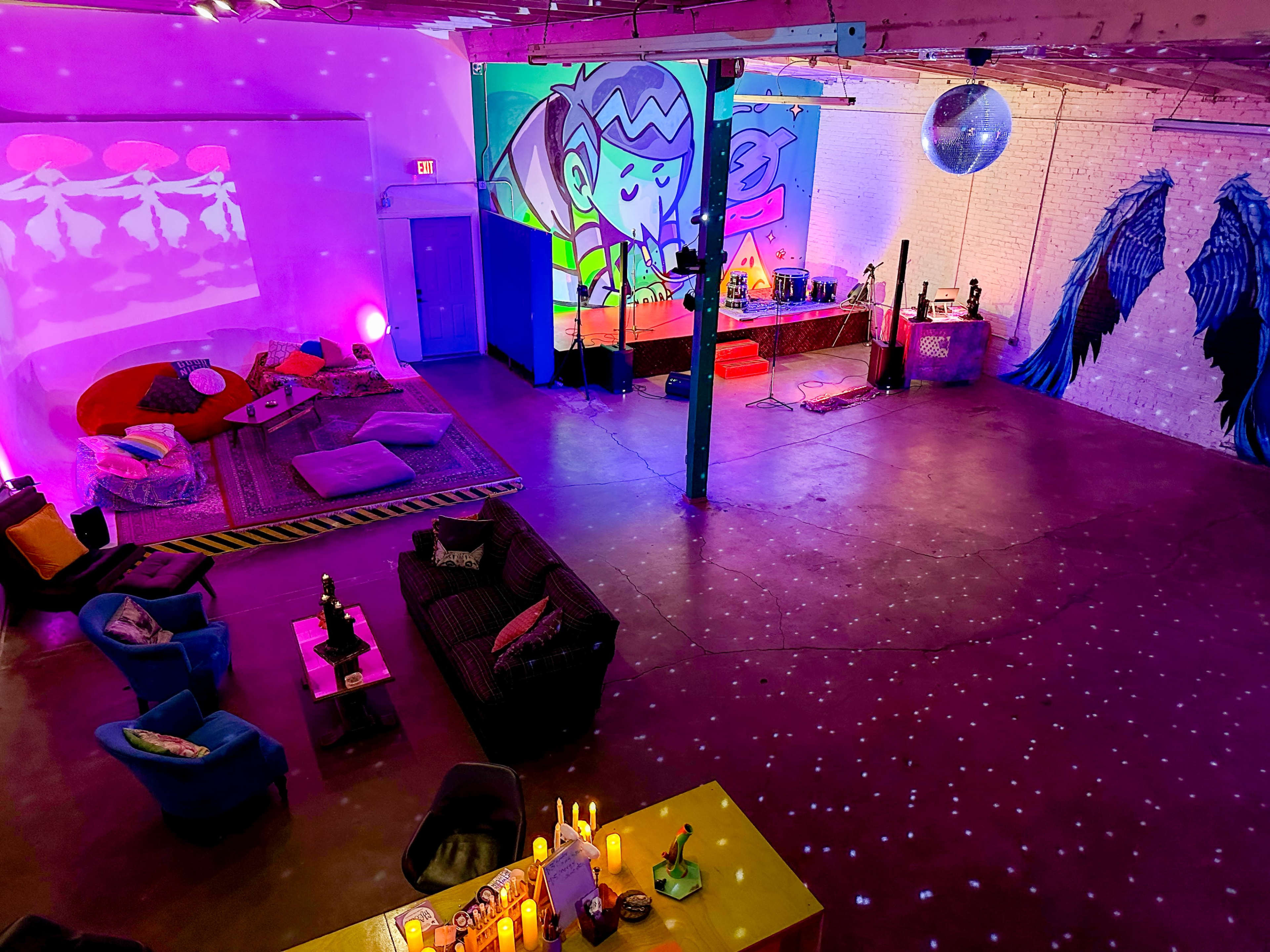 A brightly colored, spacious room with vibrant wall murals, various seating areas, and decorative lighting.