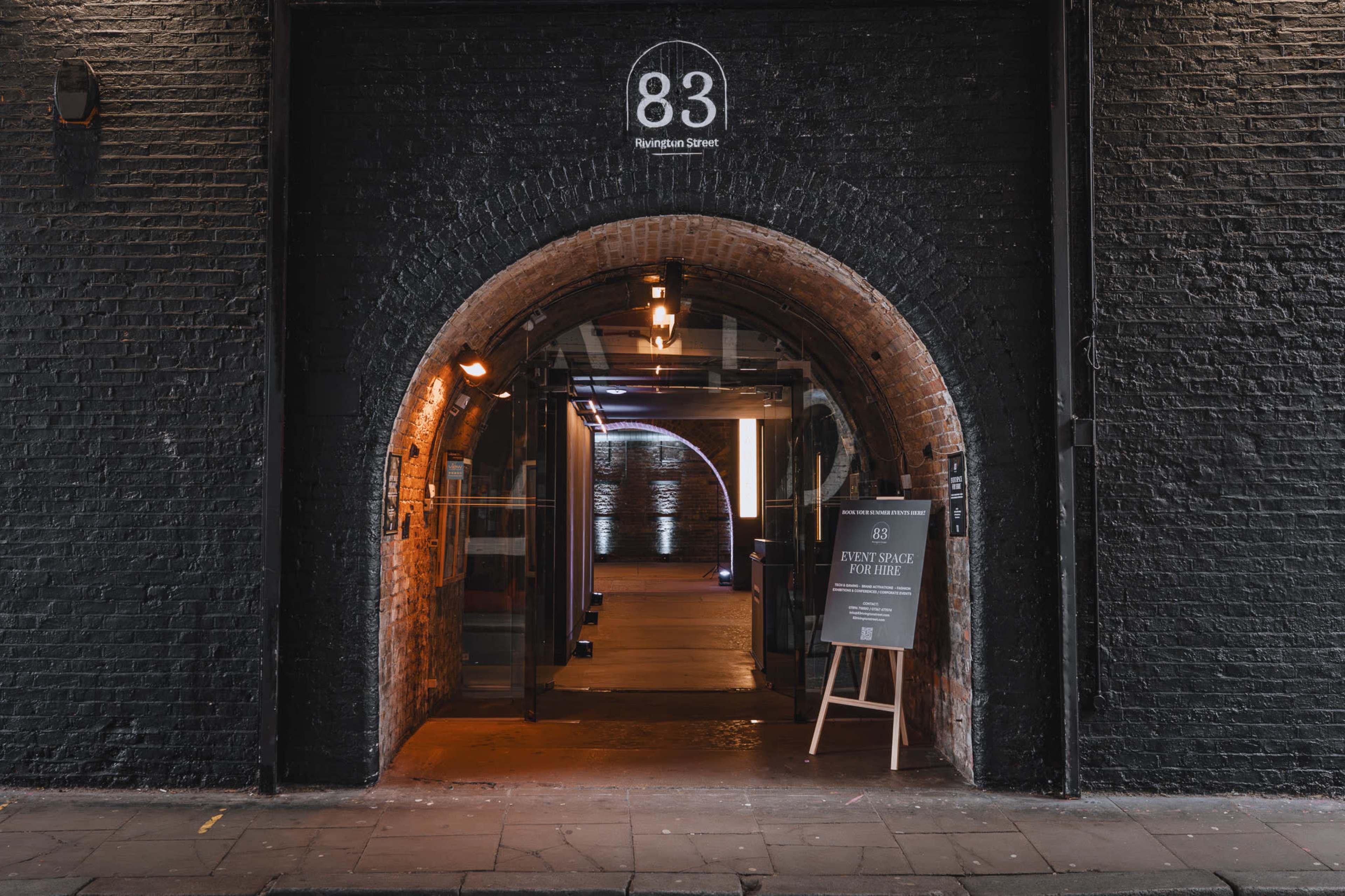 The image shows an entrance to a building at 83 Rumlestone Street, featuring an archway and a sign indicating a space available for hire.