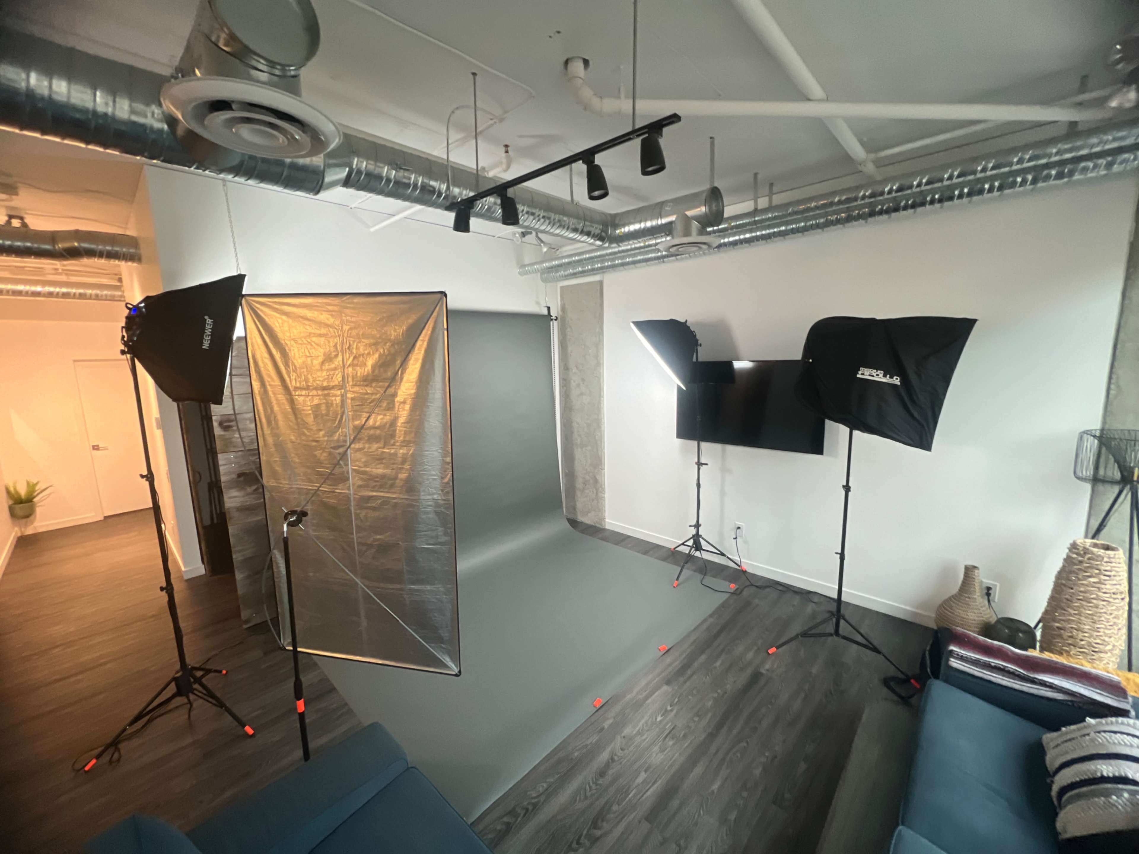 A modern photography studio setup with lighting equipment and a seamless backdrop.