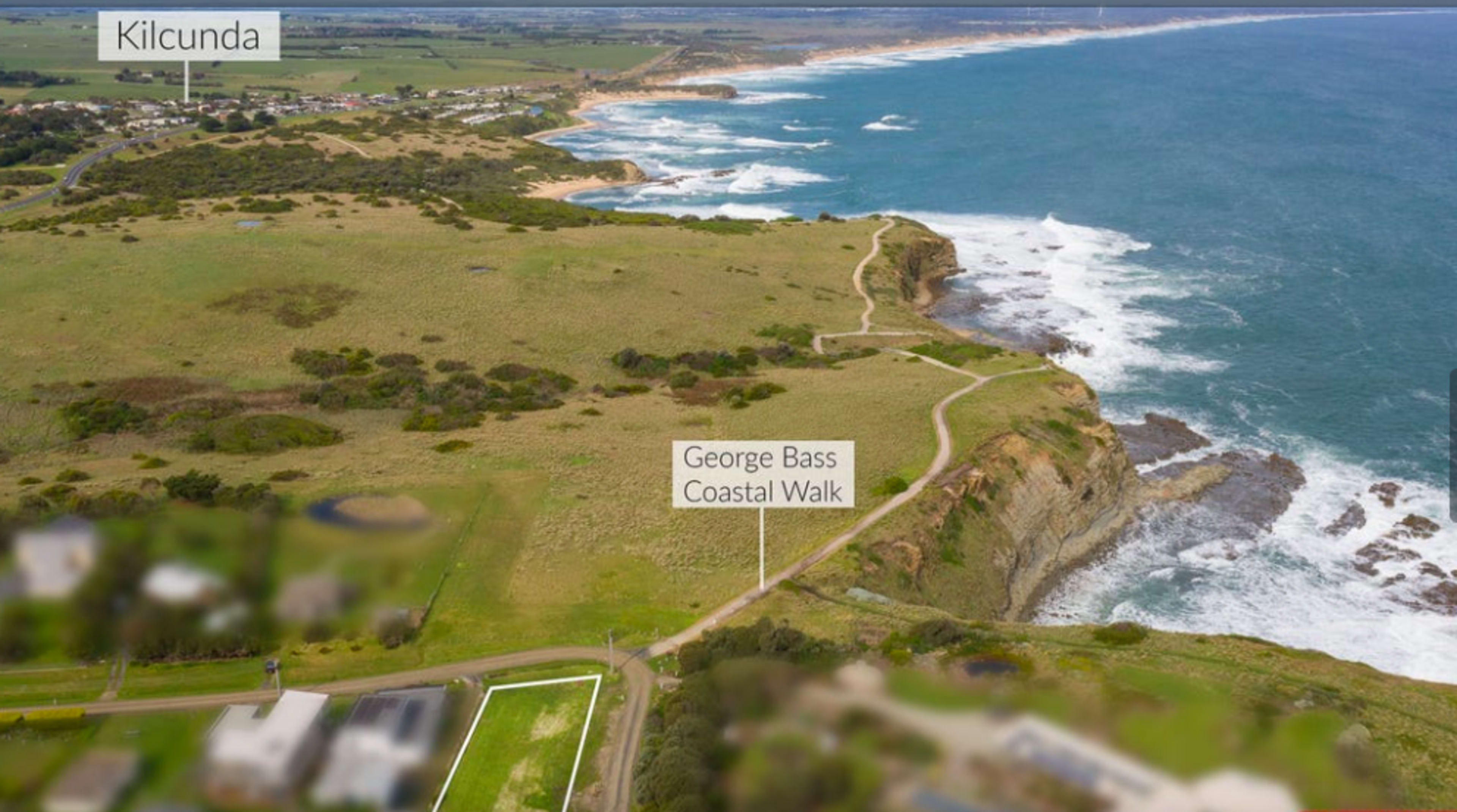 The image shows an aerial view of Kilcunda, Australia, highlighting the George Bass Coastal Walk along rugged cliffs and the coastline.