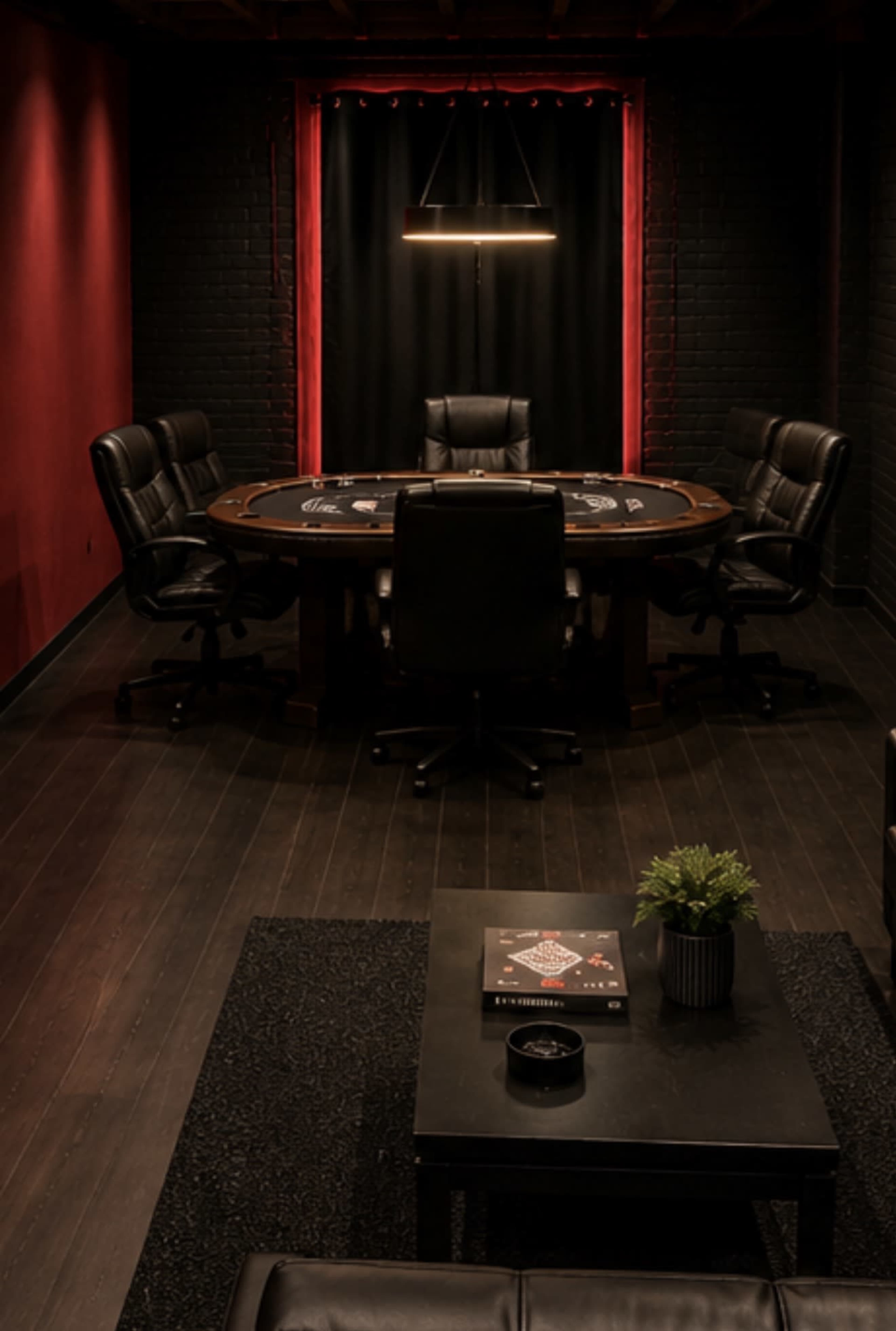 The image shows a dimly lit poker room featuring a round table surrounded by four black leather chairs, set against red and black walls.