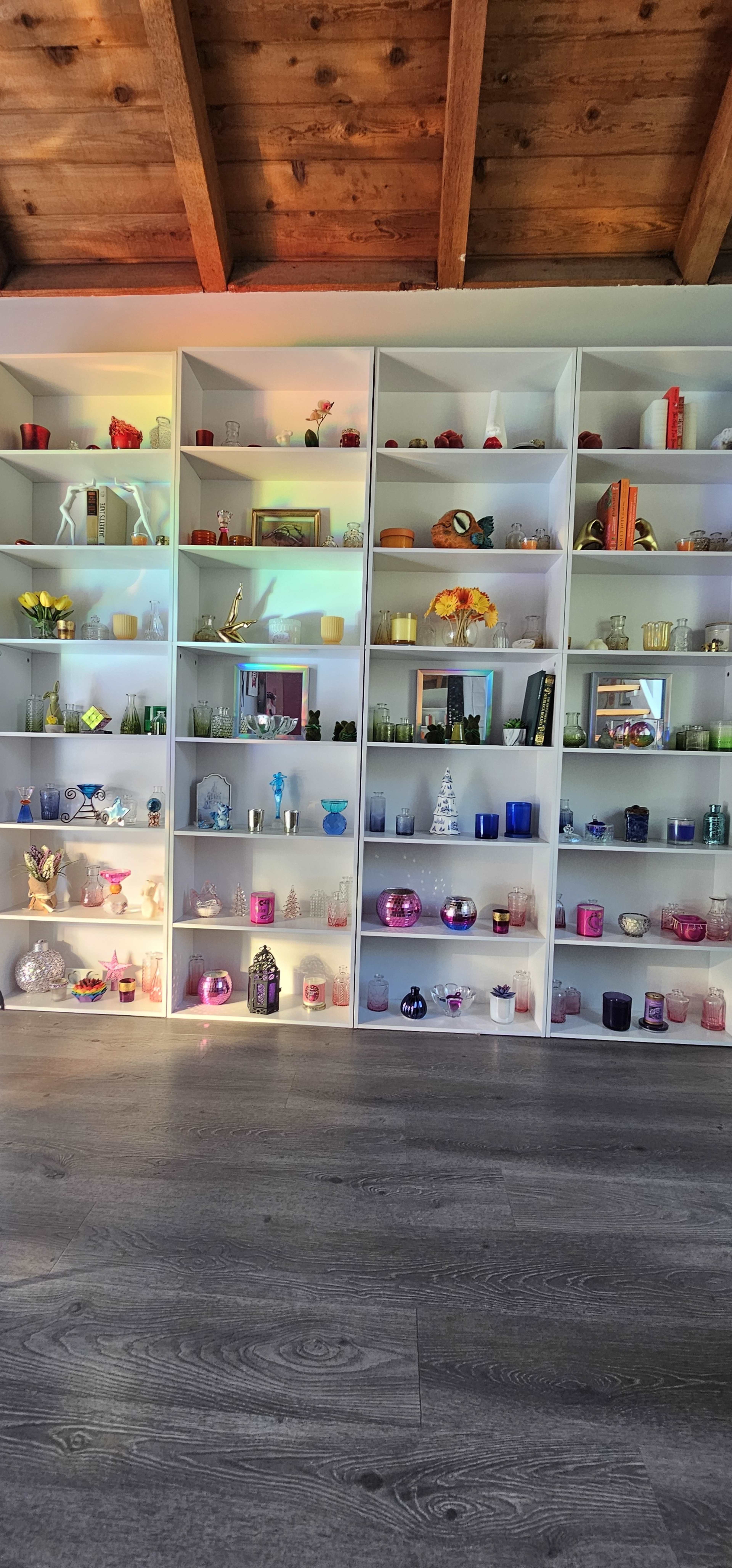 The image features a display shelf with various decorative items, including vases, candles, and ornaments arranged on multiple levels.