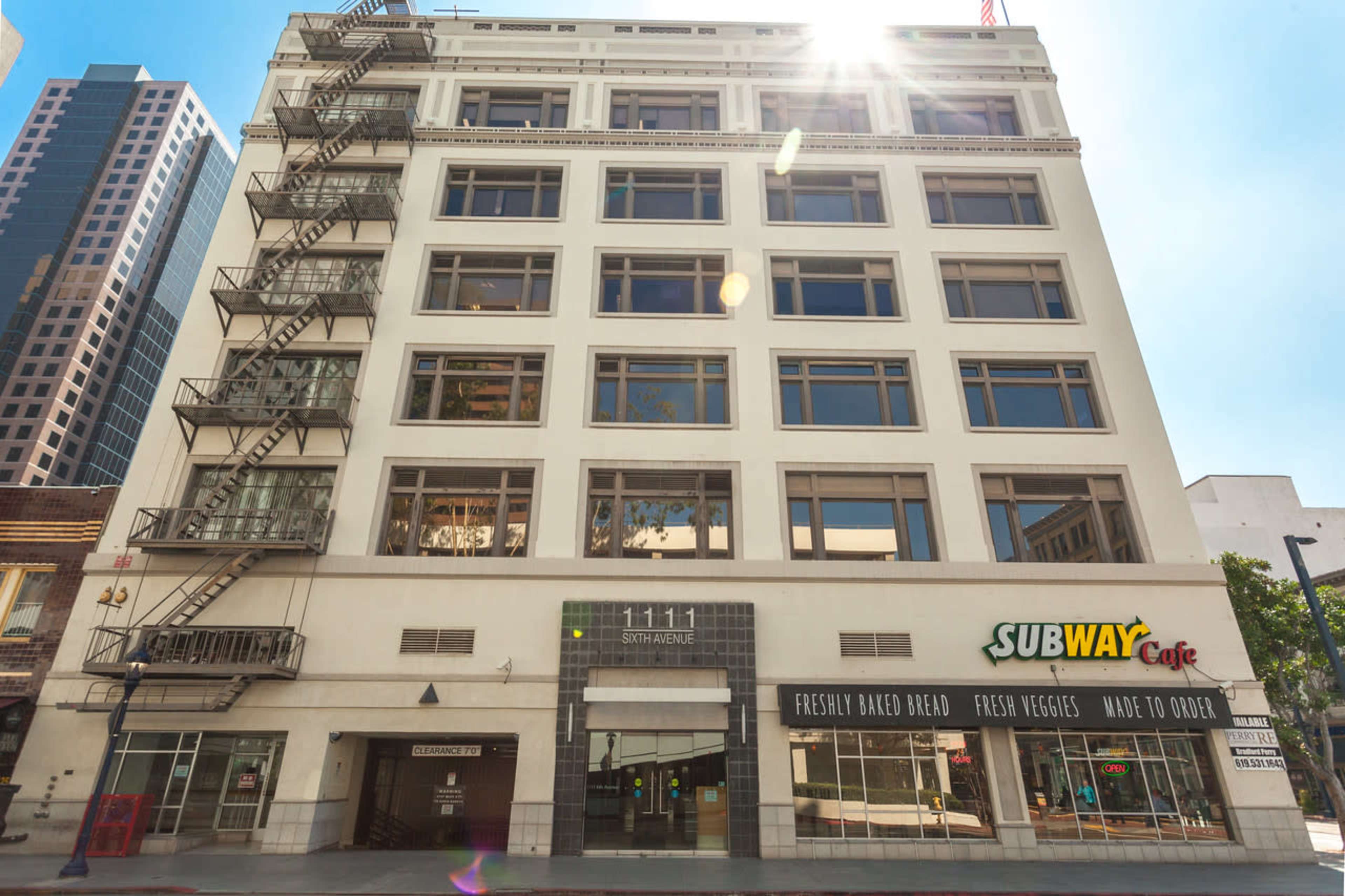 The image shows a five-story building with a fire escape on the left side and a Subway Cafe on the ground floor, located at 1111 Sixth Avenue in an urban setting.
