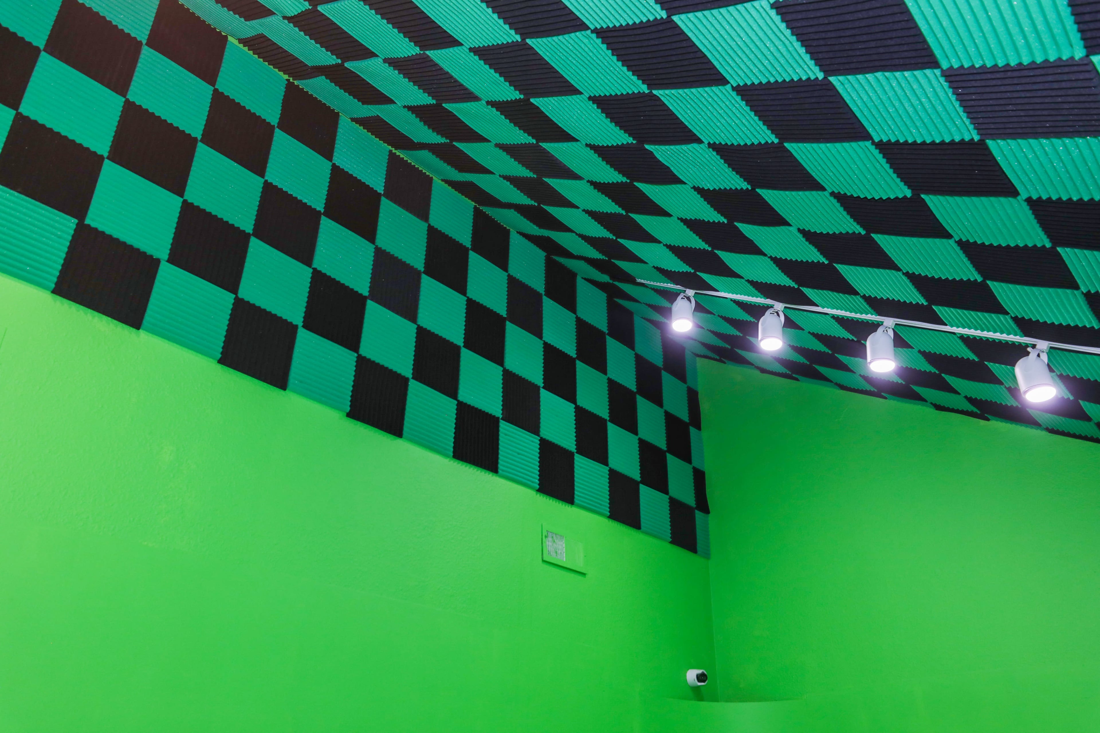 The image shows a room with a green and black checkered ceiling and bright green walls.