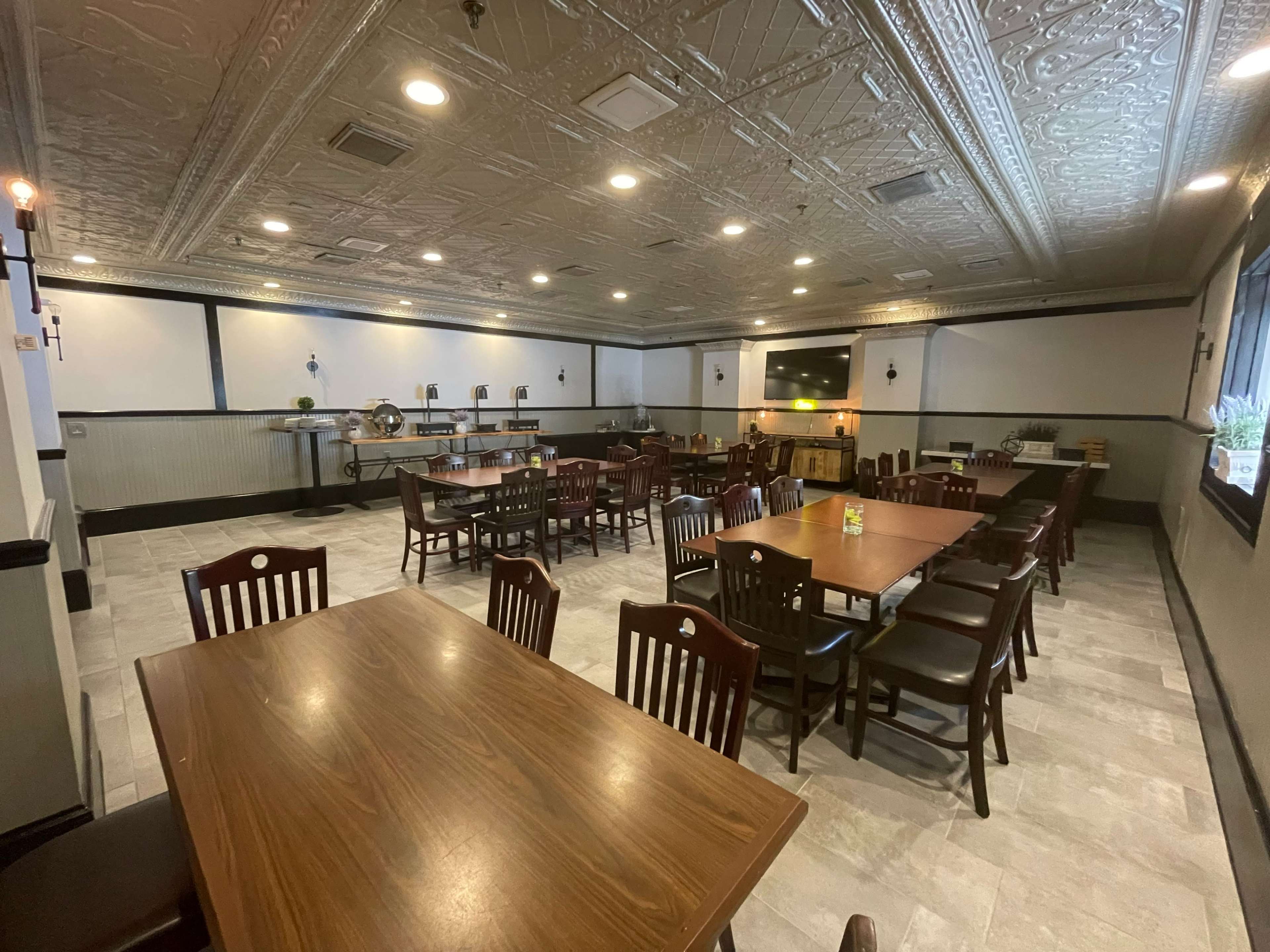 A spacious dining area with several wooden tables and chairs arranged neatly in a restaurant setting.