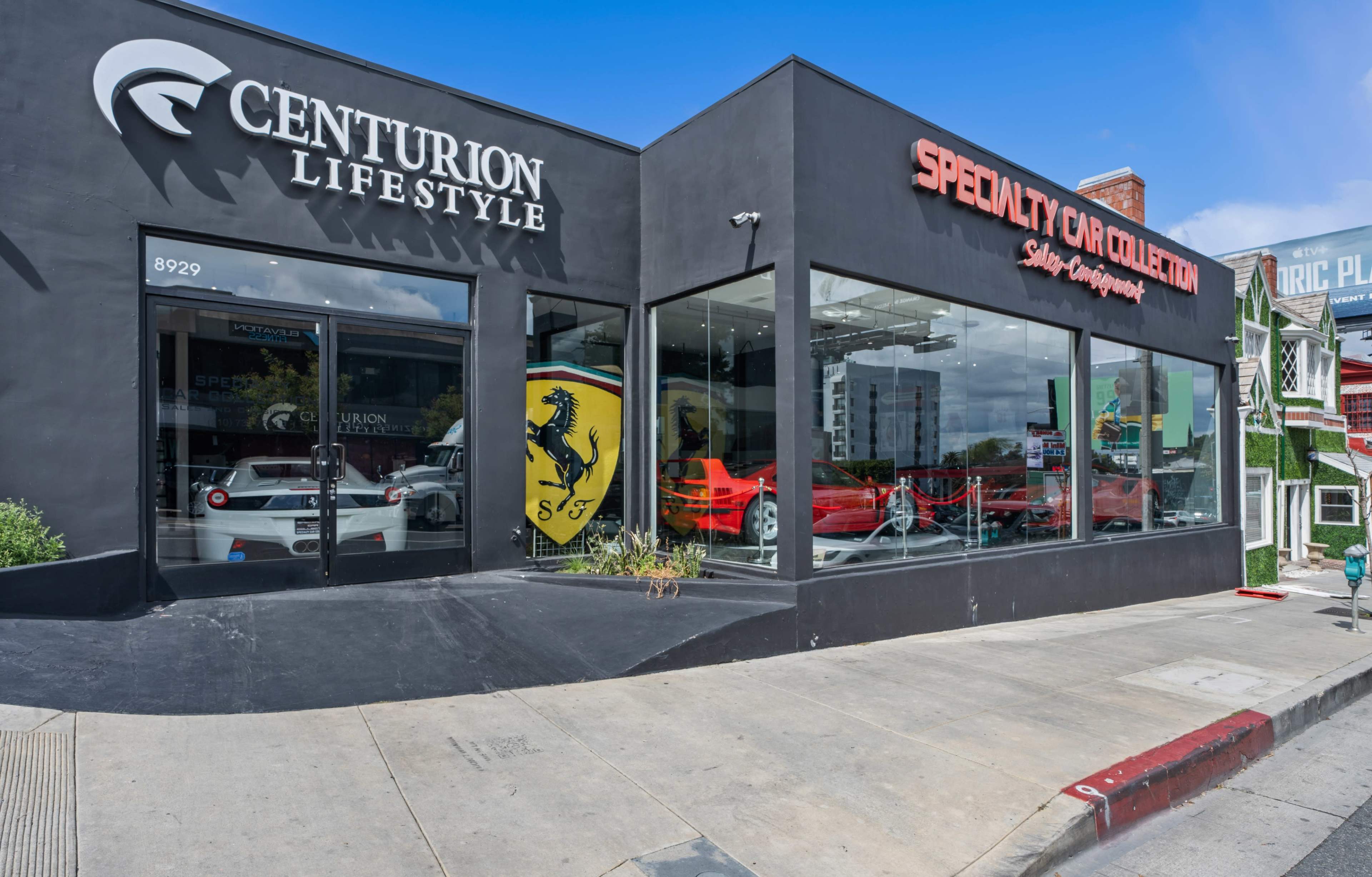 A storefront featuring a luxury car showroom with a red Ferrari displayed in the window alongside the branding of "Centurion Lifestyle" and "Specialty Car Collection."