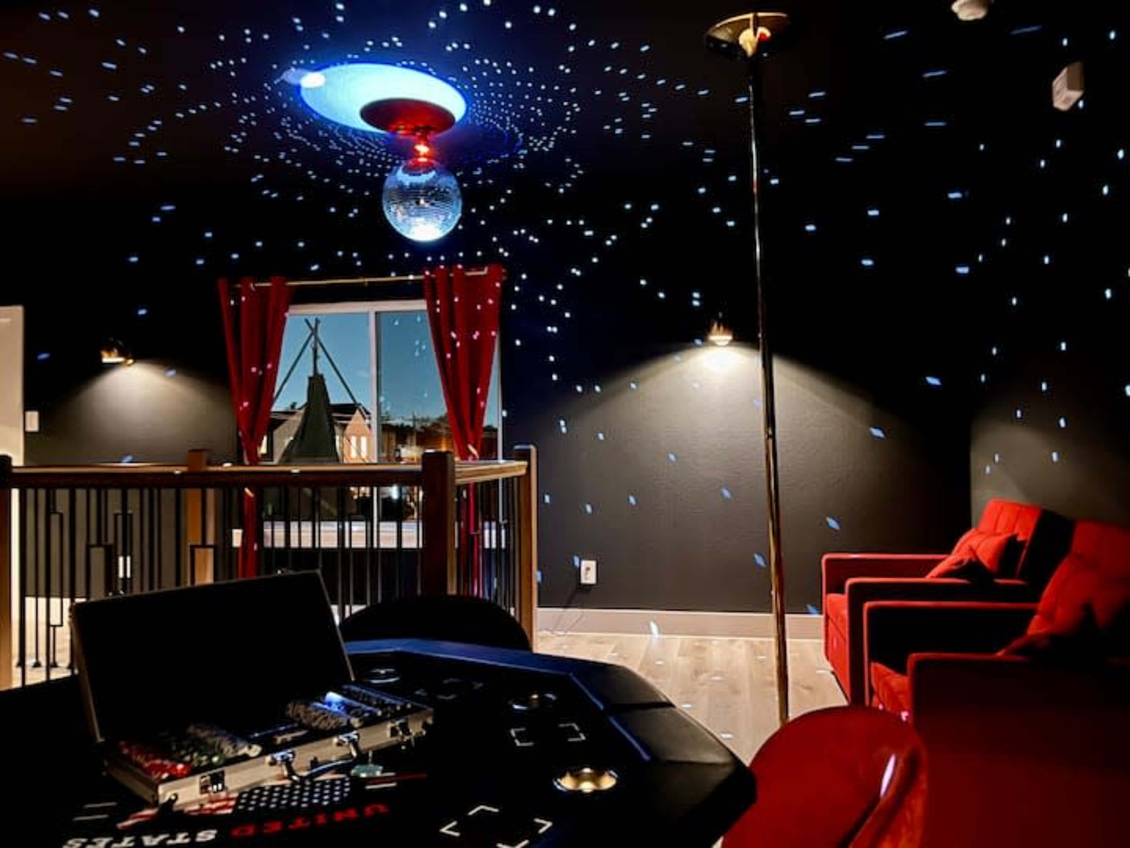 The scene features a modern entertainment room with a disco ball reflecting light onto the ceiling, red curtains, and a black poker table with electronic equipment.
