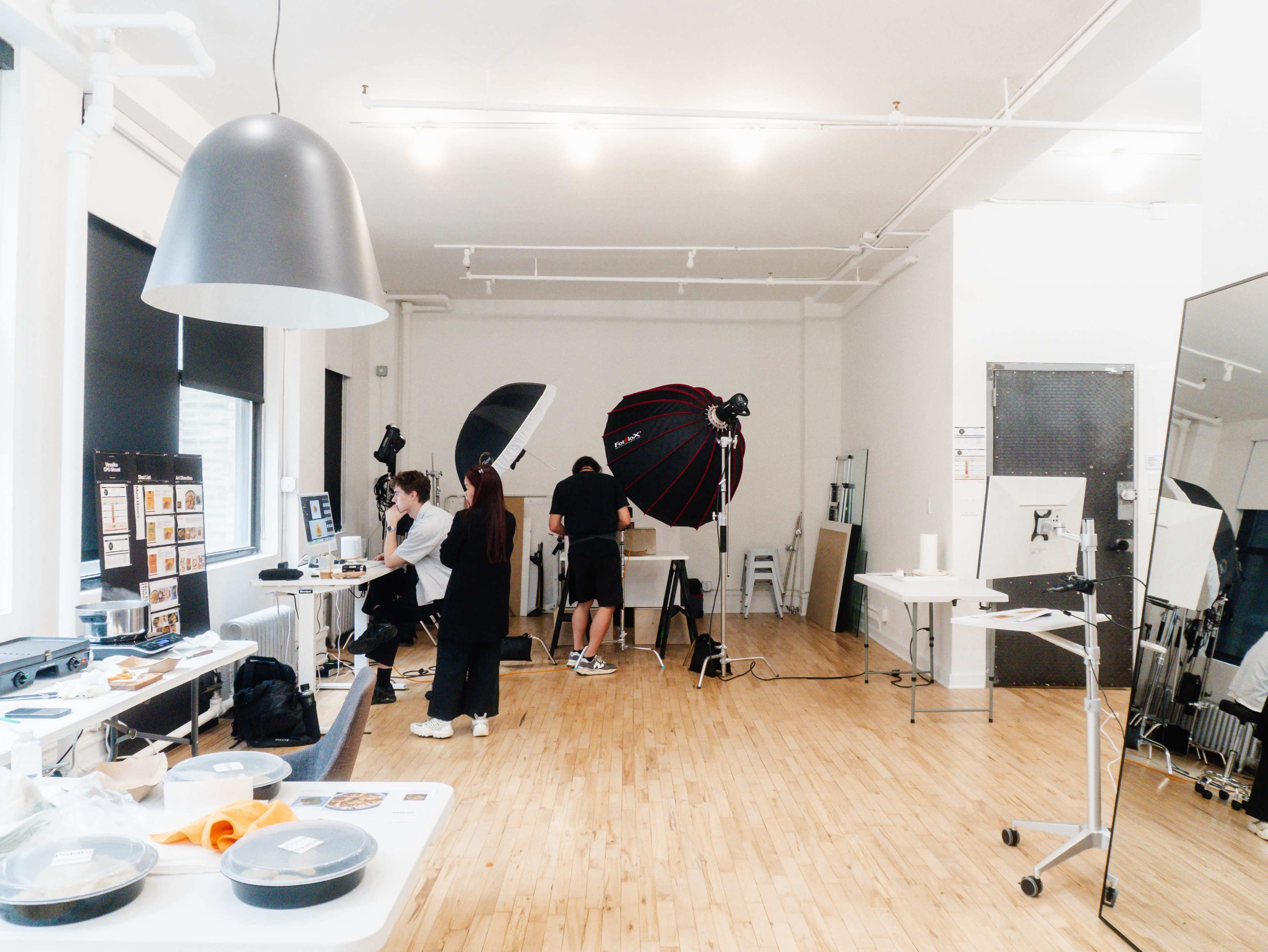 A photography studio features multiple lighting setups and equipment while several people work on a project.