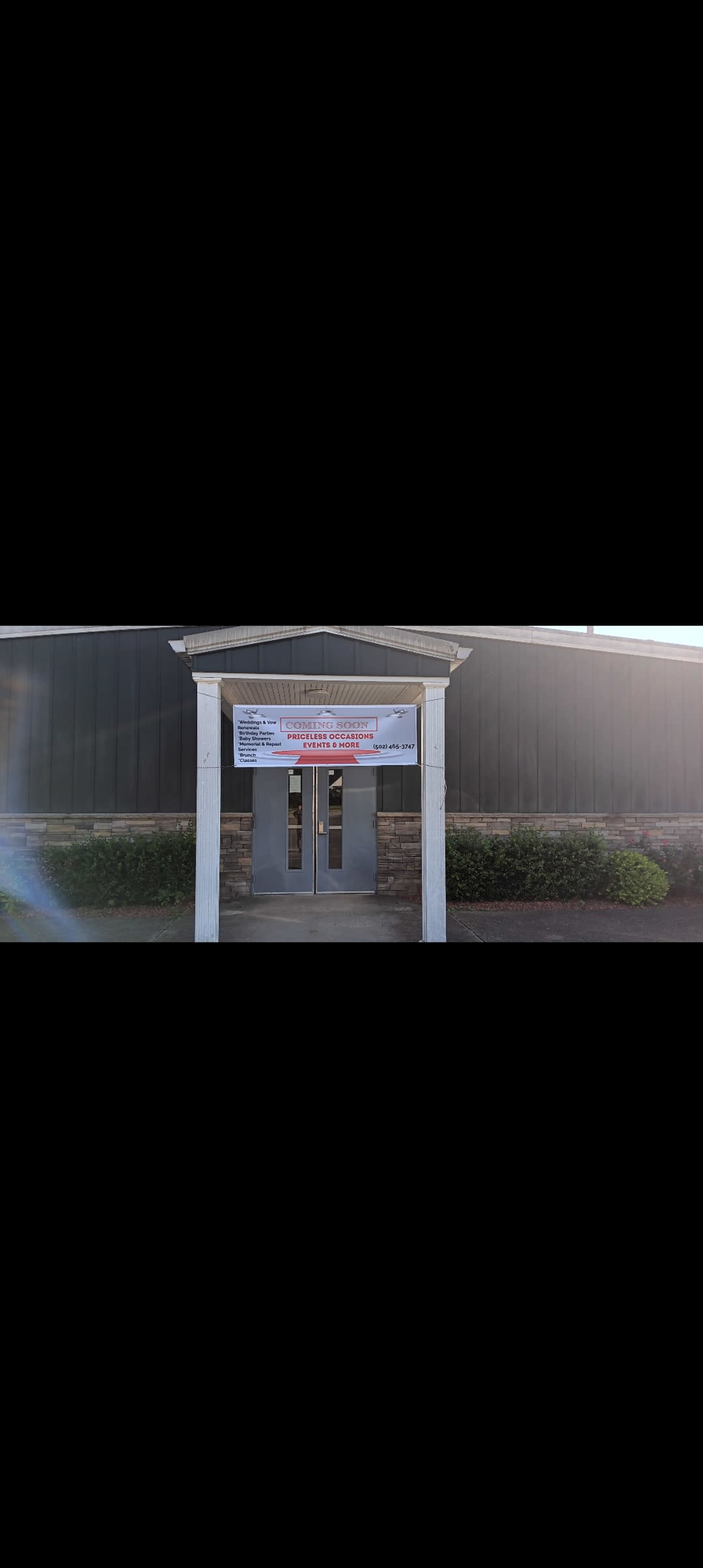 The image shows the entrance of a building with a large banner displayed above the double doors.