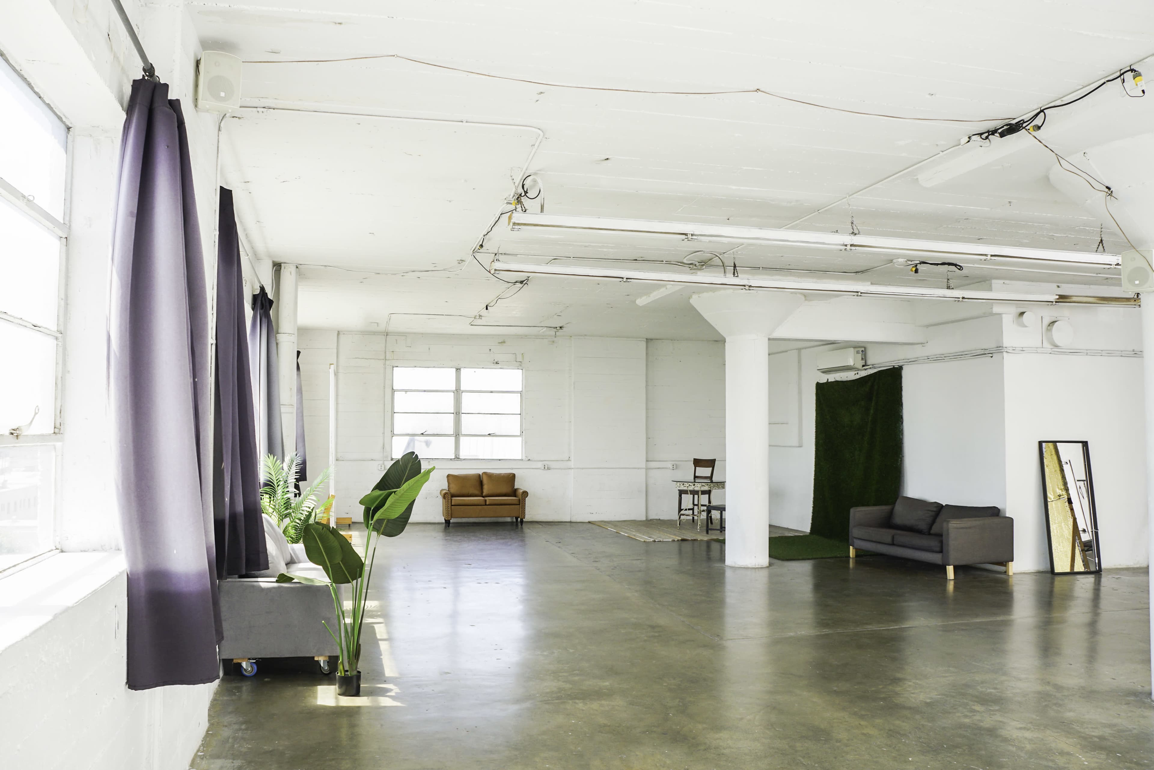 Blackout Loft Studio with central AC, a pre-lit corner cyc wall, Light Tunnel, wooden platform, white wooden reclaimed wall & frameless window with downtown view - PRO II Image in Central LA, Los Angeles, CA