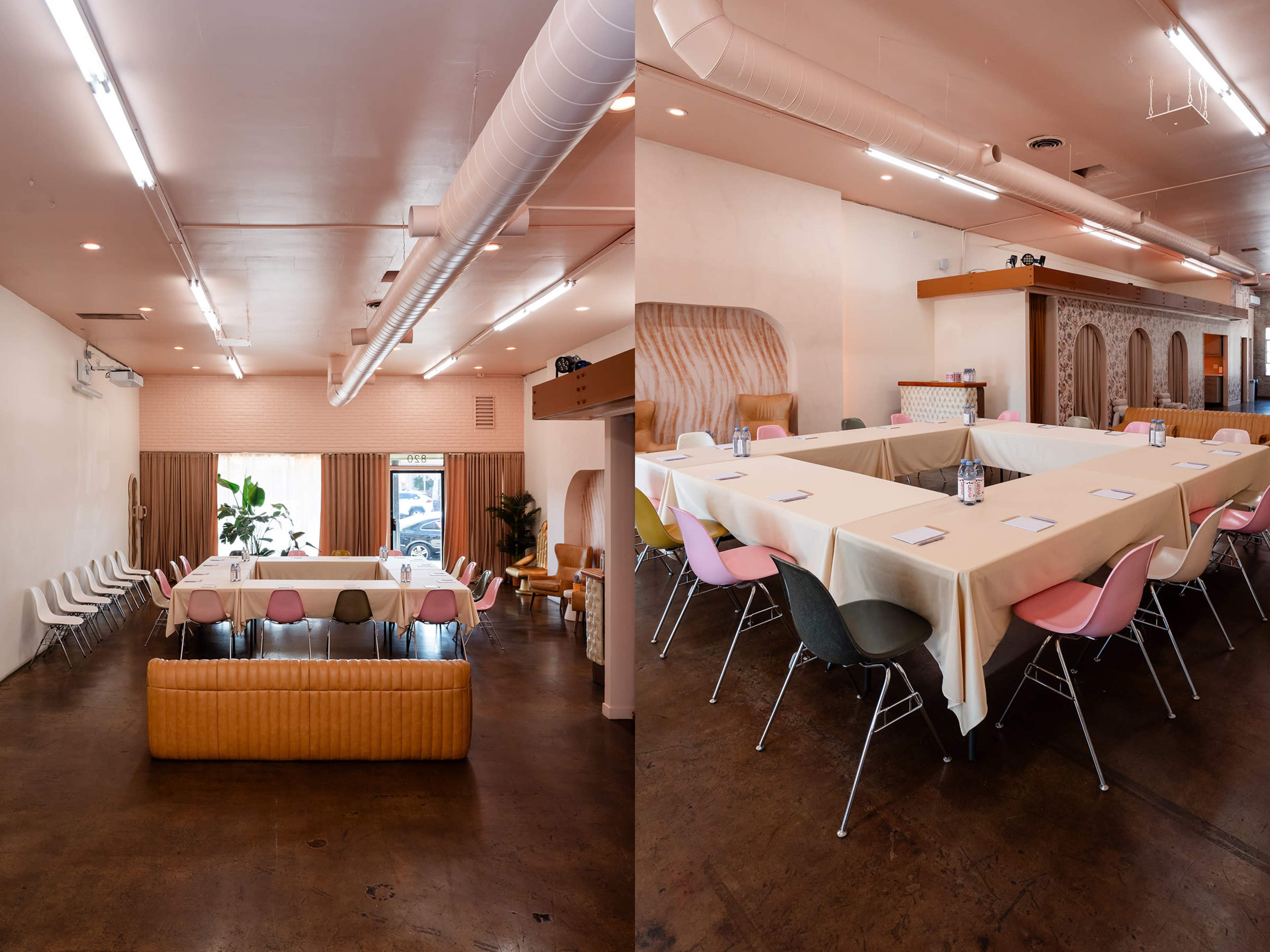 The image shows a spacious room designed for meetings, featuring a large rectangular table covered with a tablecloth, surrounded by various chairs, and bright lighting above.