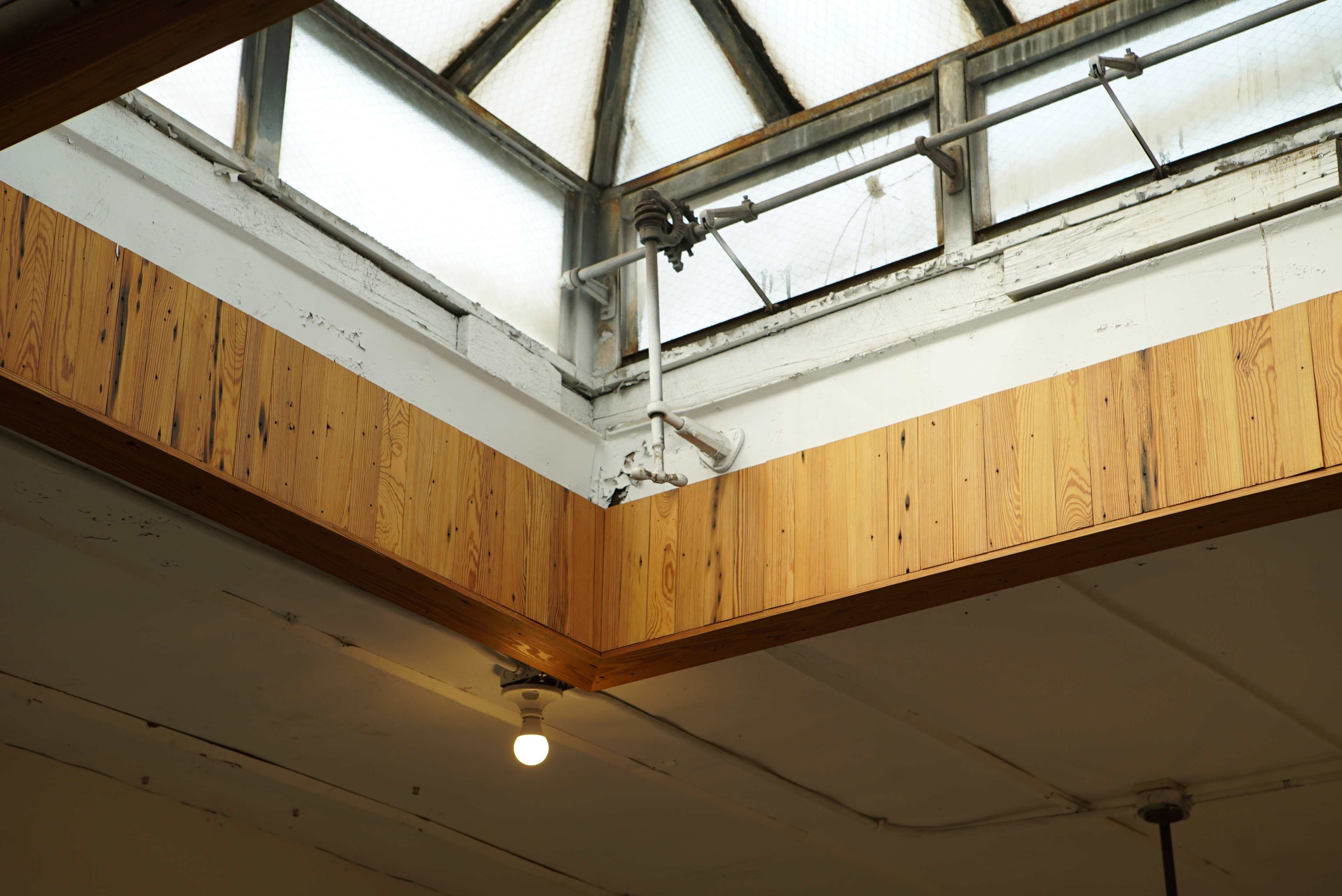 The corner of a room with wooden paneling and a skylight above.